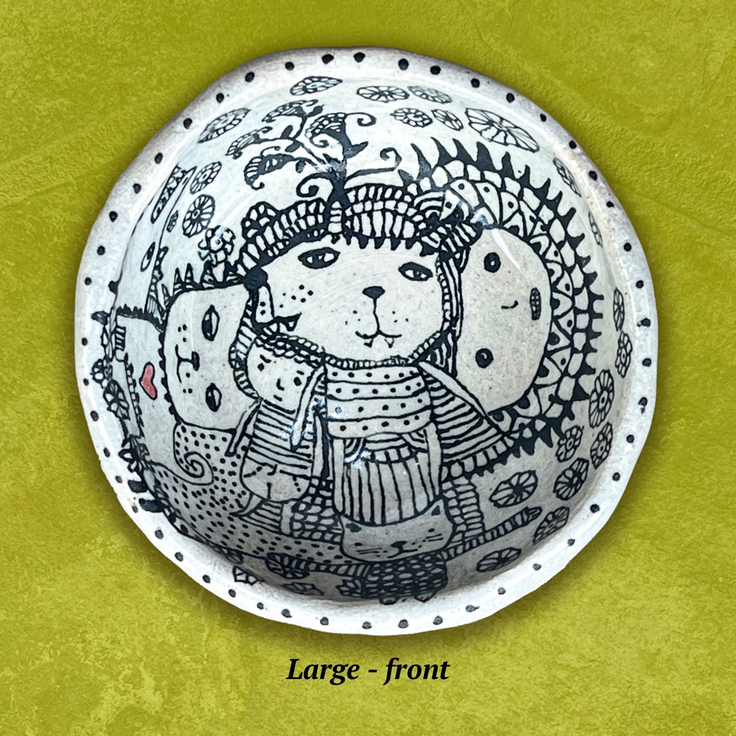 Circular bowl with a stylized bear wearing a hat and scarf. Black and white with a small red heart.