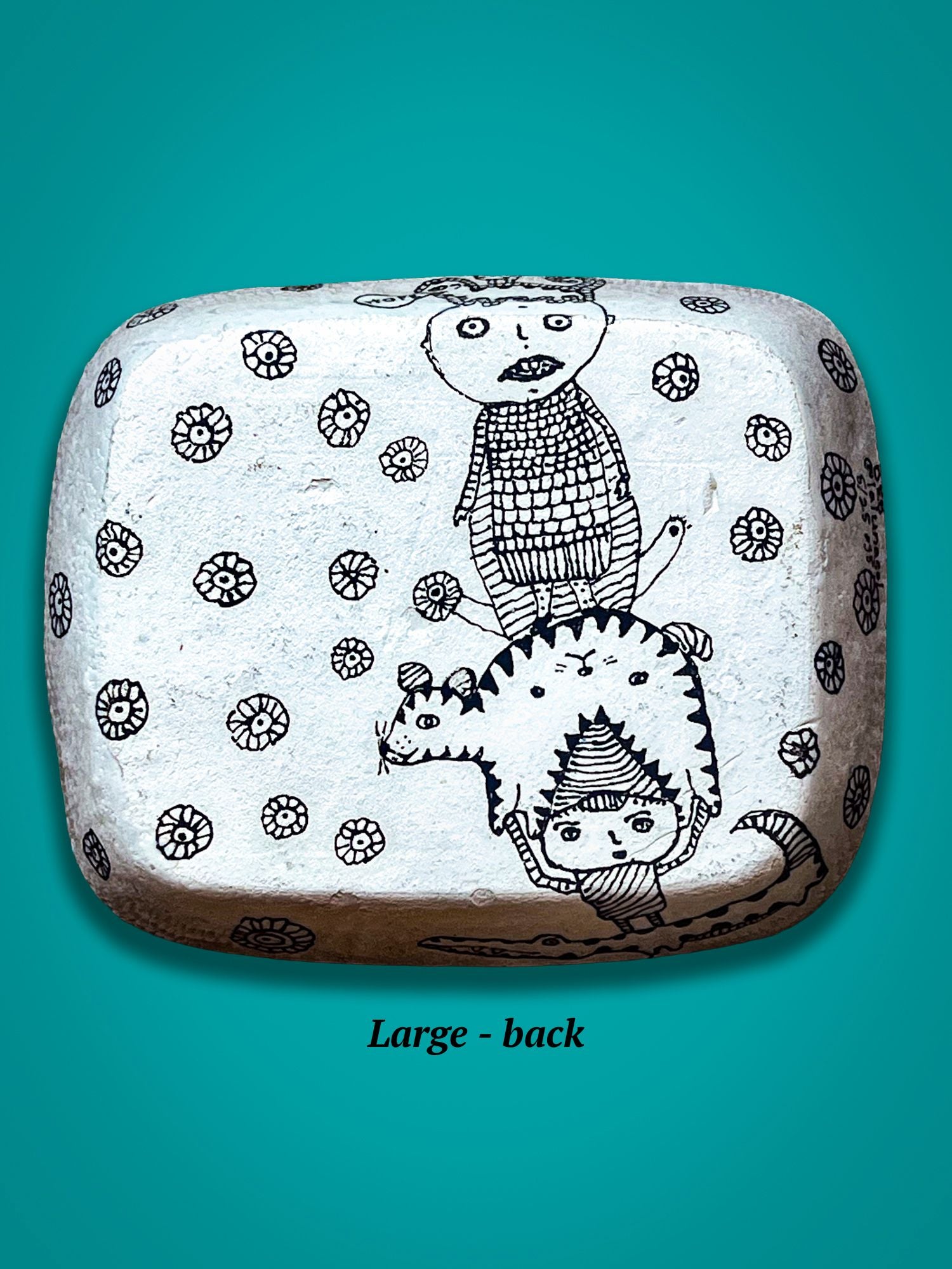 This is the back of rectangular plate with black illustrations. Small boy stands on top a cat being held by another boy. This surface is not glossed, but is complete with figure drawings.