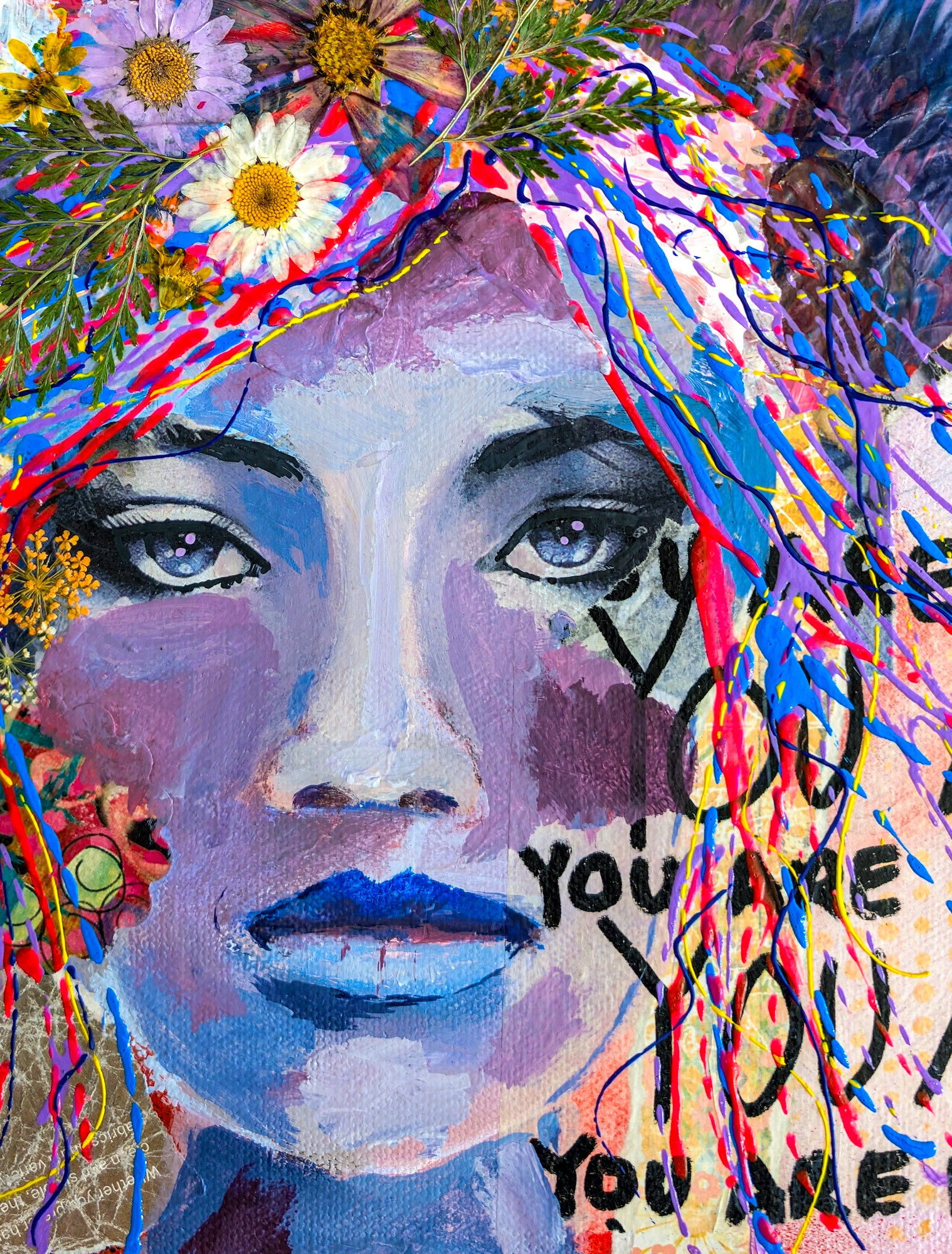 Colorful abstract artwork with a face and text 'YOU ARE YOU' surrounded by flowers and ribbons. This is a zoomed in look at the painting