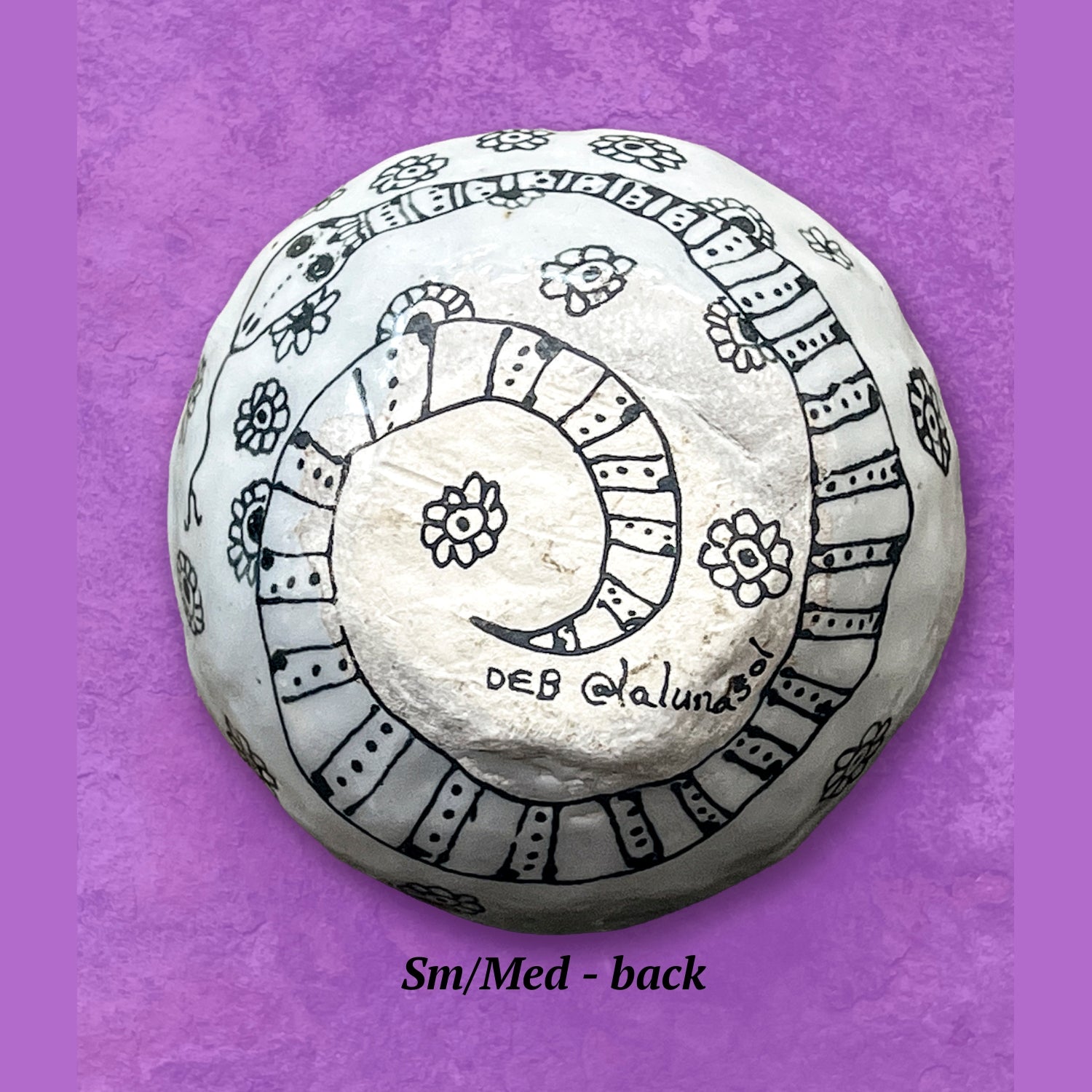 This image shows the backside of a bowl artistic design of a swirled snake. The finish is matte, not glossy like the front.