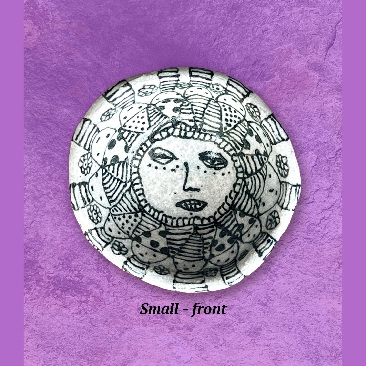 Decorative bowl with black and white sun design.