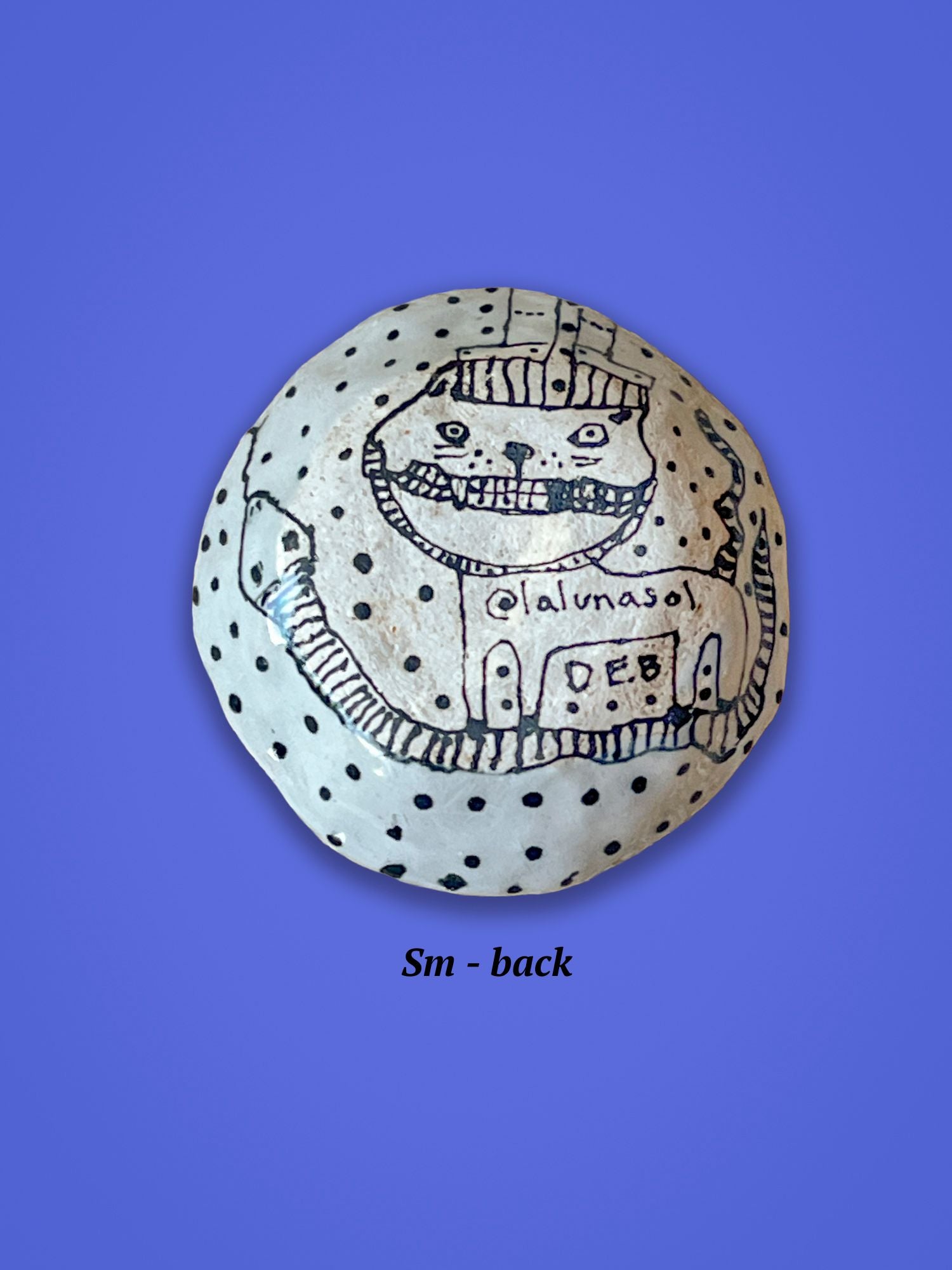 This is the backside of the previous bowl with a smiling cat standing on a snake.