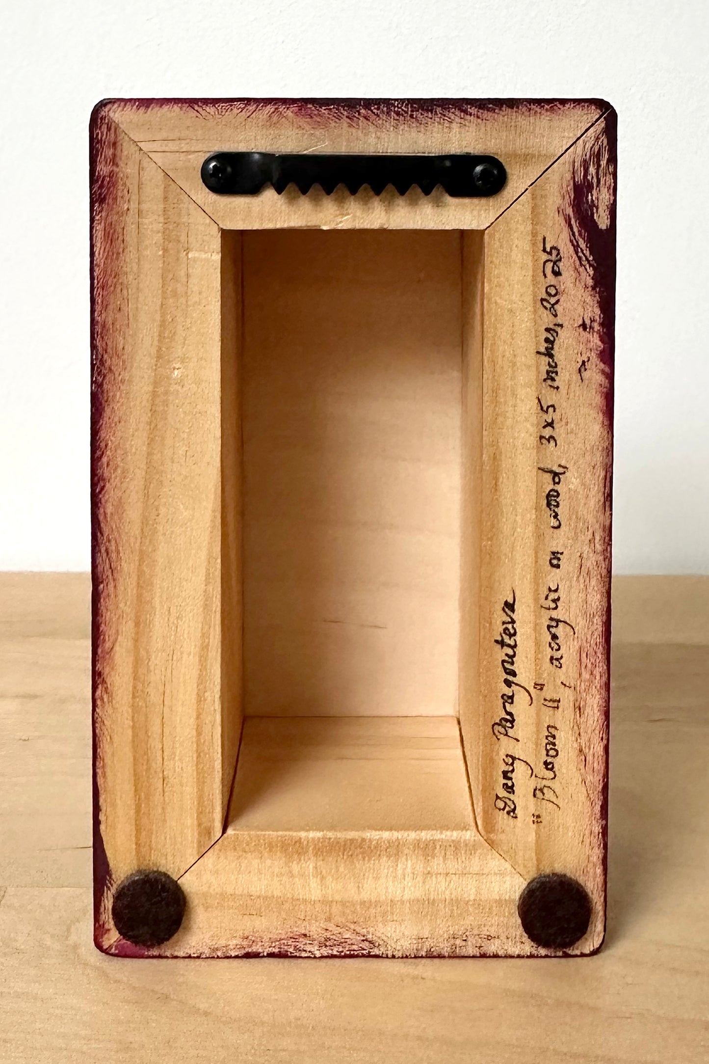 Shown here from the back. The artist has signed the piece. It includes a hanger and pads to protect the bottom edges as the painting rests against the wall as it hangs.