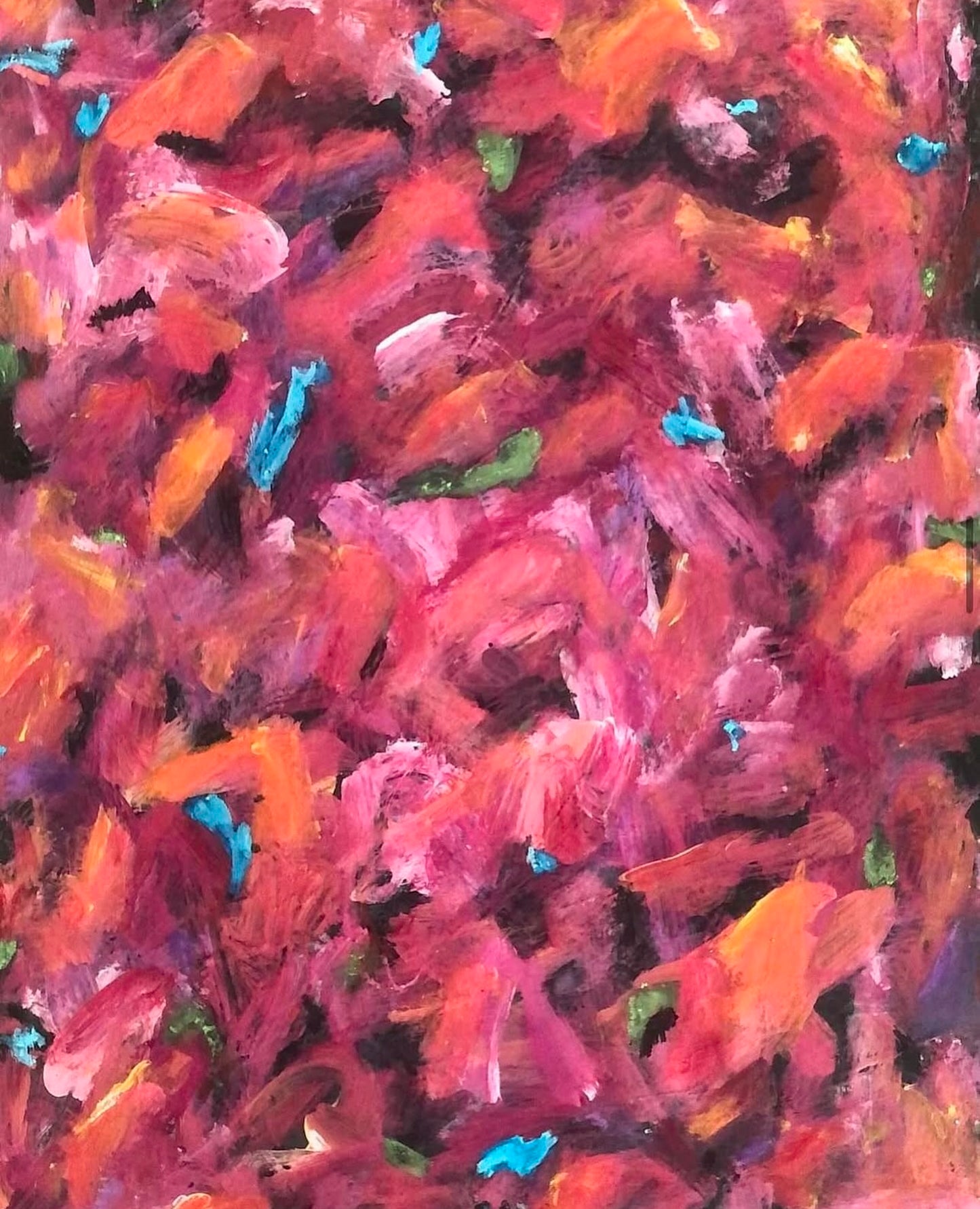 This image shows a close up of the flowers highlighting the various shades of reds, pinks and oranges that form the flowers. Small drops of blue and green also show.