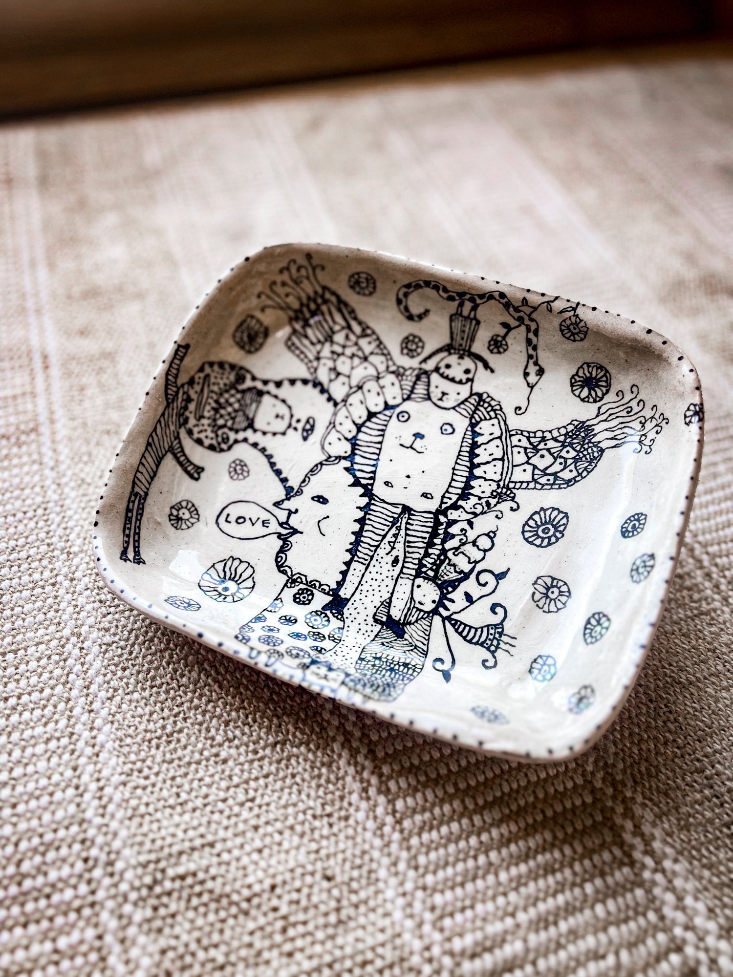 Decorative ceramic dish with black and white illustrations on a textured surface. This image shows the dimensions.