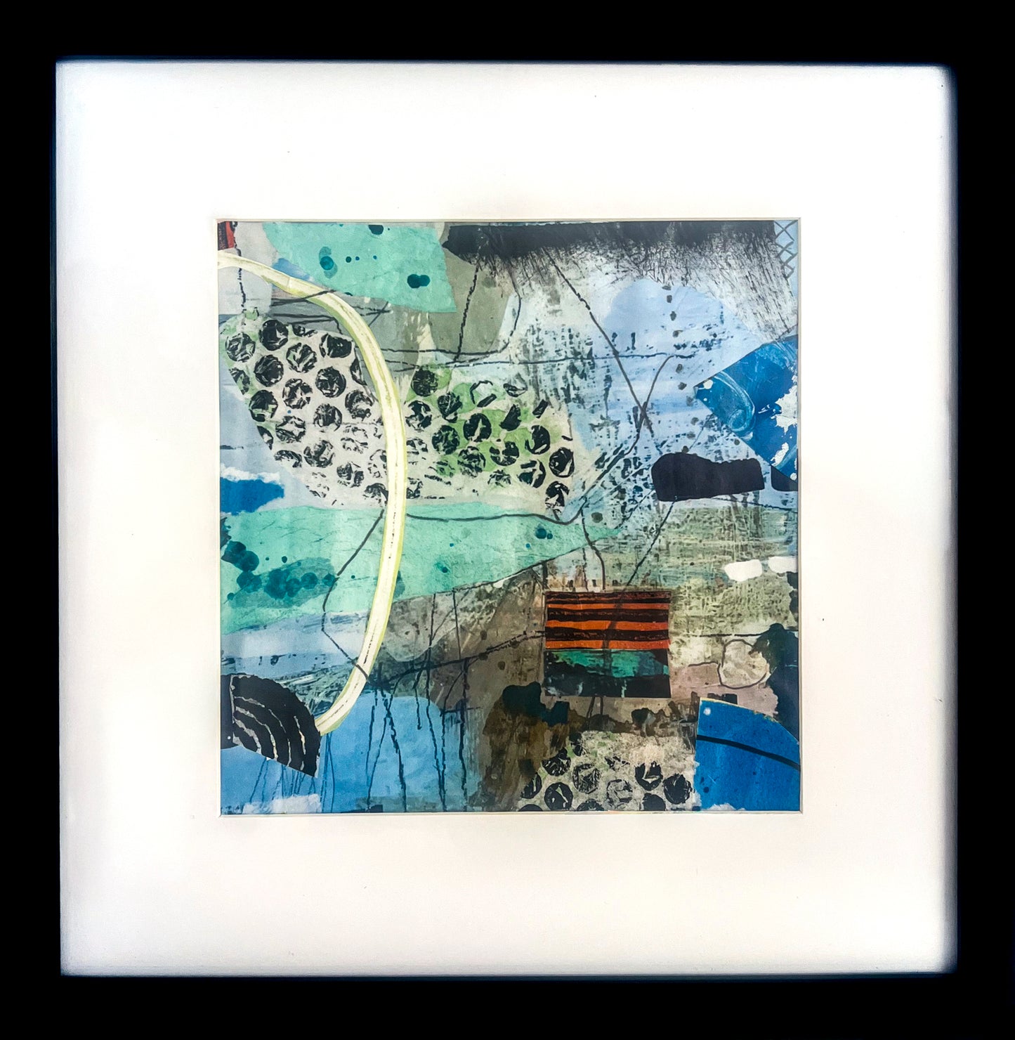 'Lasting Impressions' is a mixed media painting and collage using a blue and green palette with a patch of orange and black stripe; shown in 1" black wood frame w/2" white mat.