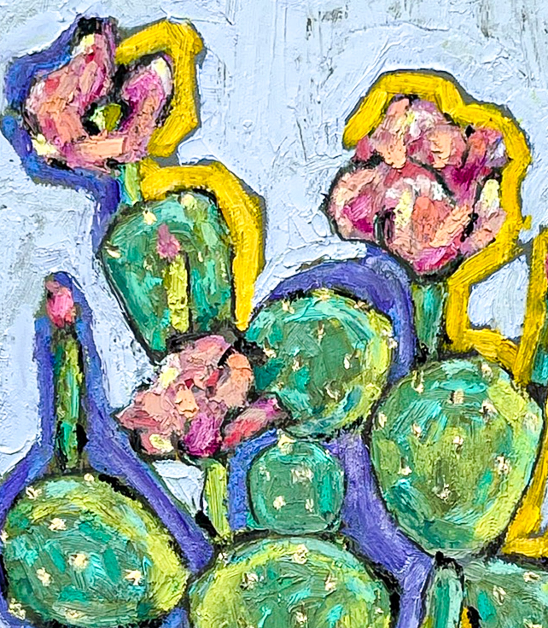 This close up image shows the various shades of greens and pinks in the leaves and blooms of the cactus. You can see the dots which represent the spines on the prickly pear The background is light blue.