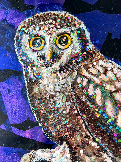Closeup of colorful acrylic painting of owl on blue background; owl is comprised of various colored sequins; resin coating on top; artist Marie Lavallee