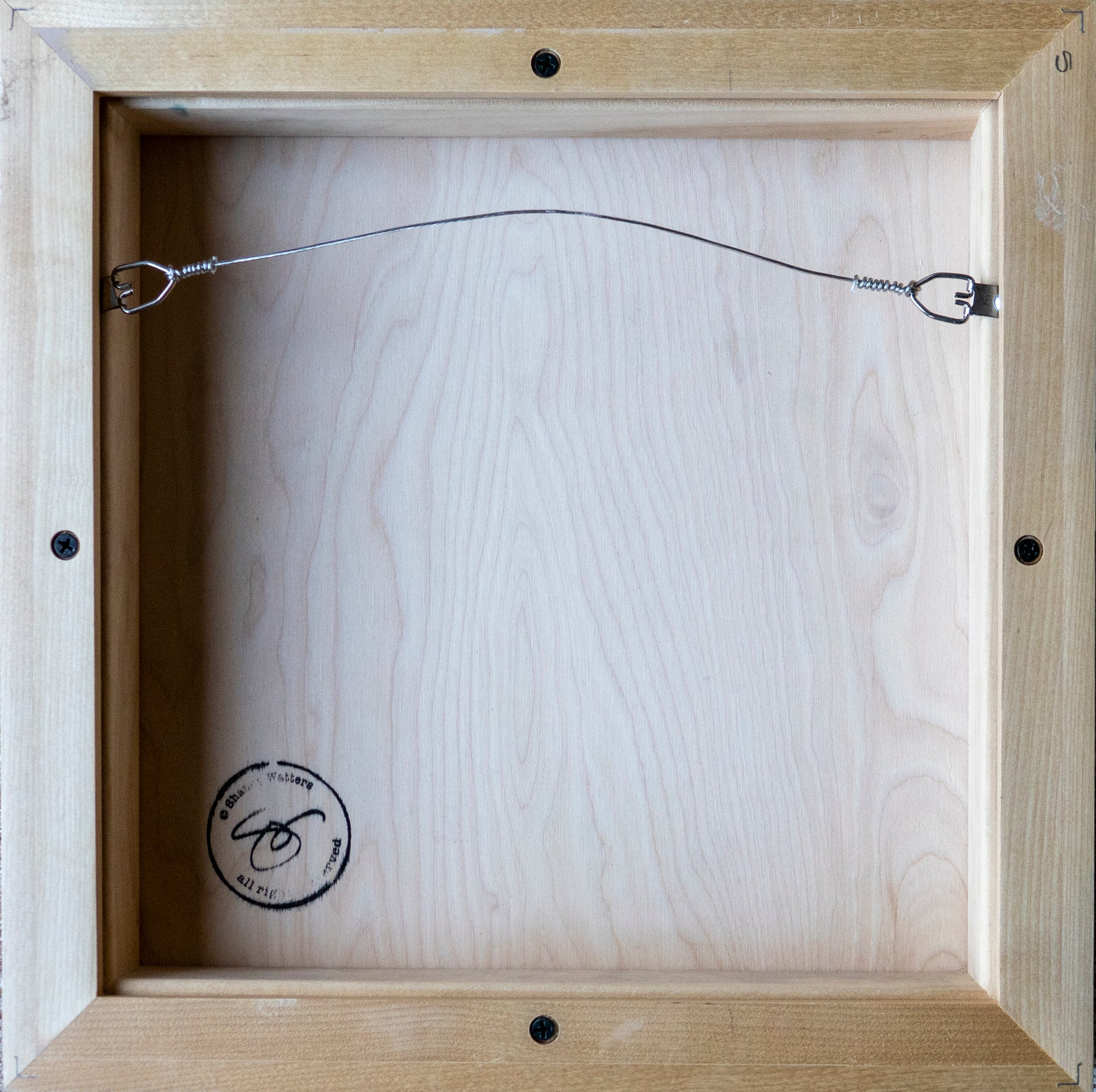 Image of back of raw maple float frame used for painting of two Kingfishers with hanging wire; artist Shaney Watters