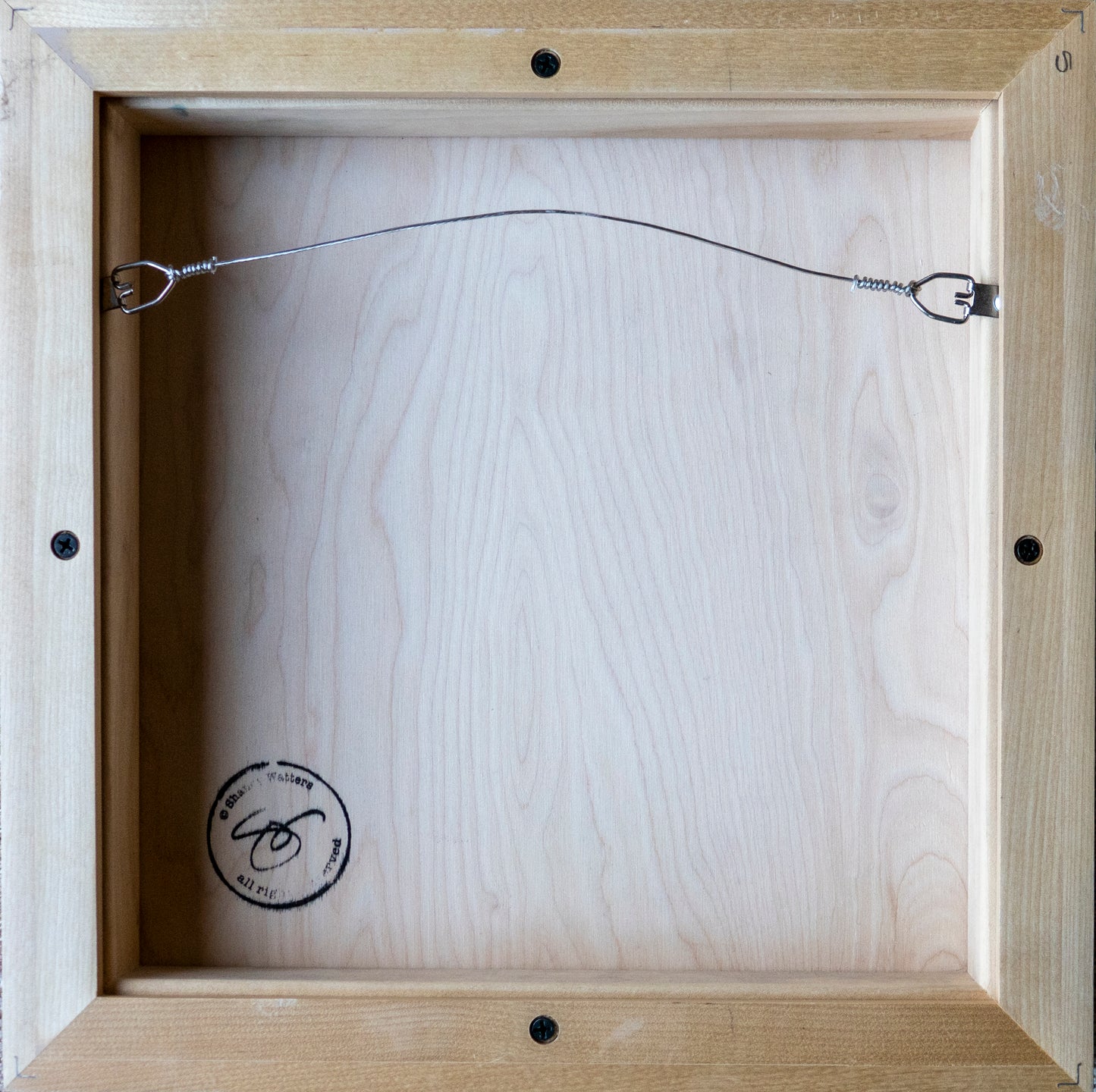Image of back of raw maple float frame used for painting of two Penguins with hanging wire; artist Shaney Watters