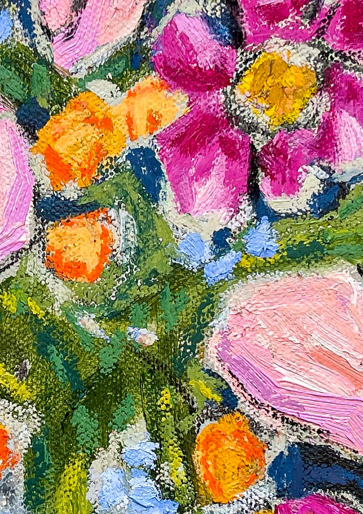 This close up image shows the number of colors that make up the floral bouquet. Greens for the leaves, orange buds and pink flowers.