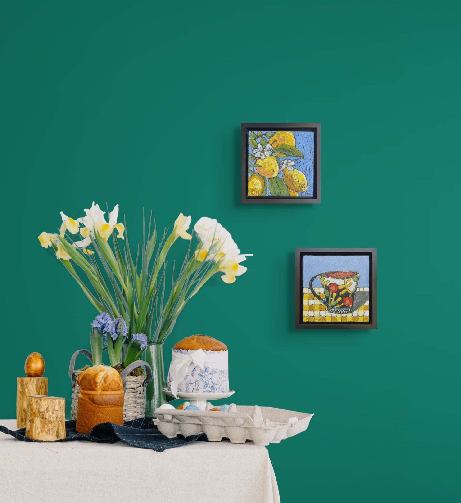 Shown here as a set, Lemon Zinger and Afternoon Tea hang of a green wall next to a beautiful tabletop setting. On a white table cloth are flowers and an array of pastries.