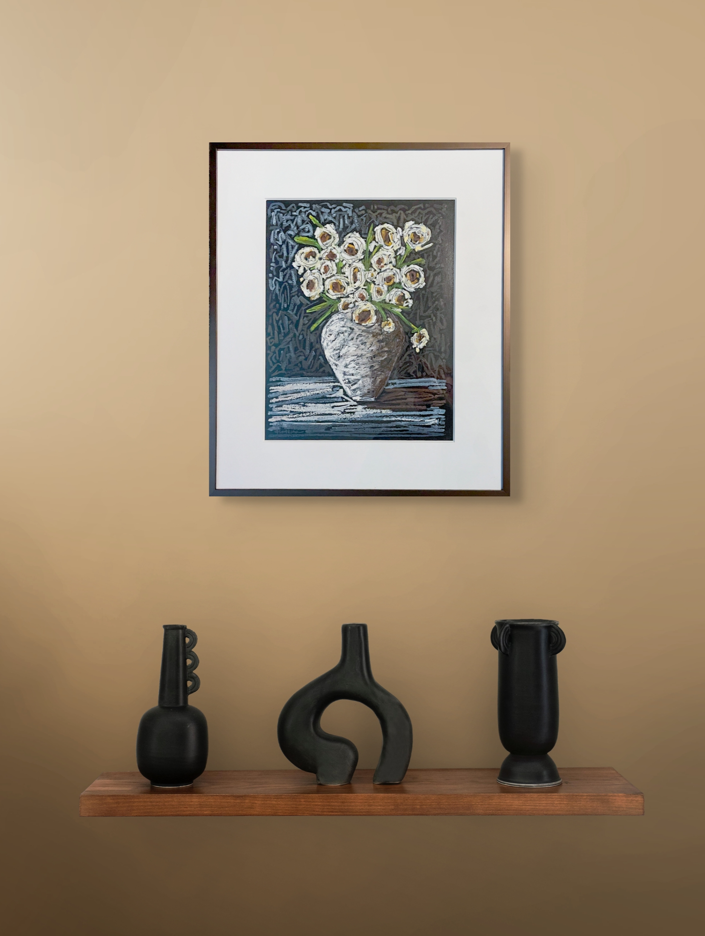 This in situ image shows a framed Black Tie hanging on a light copper wall hanging over a floating shelf with three black sculptures.