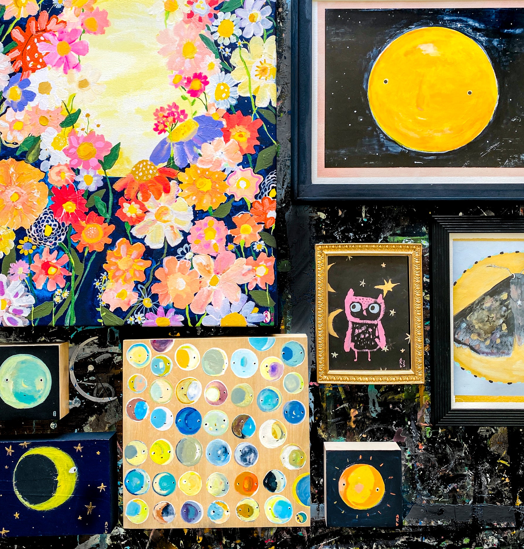 In situ photo of 7 of April Bedard's variety of paintings of moons placed together on wall.