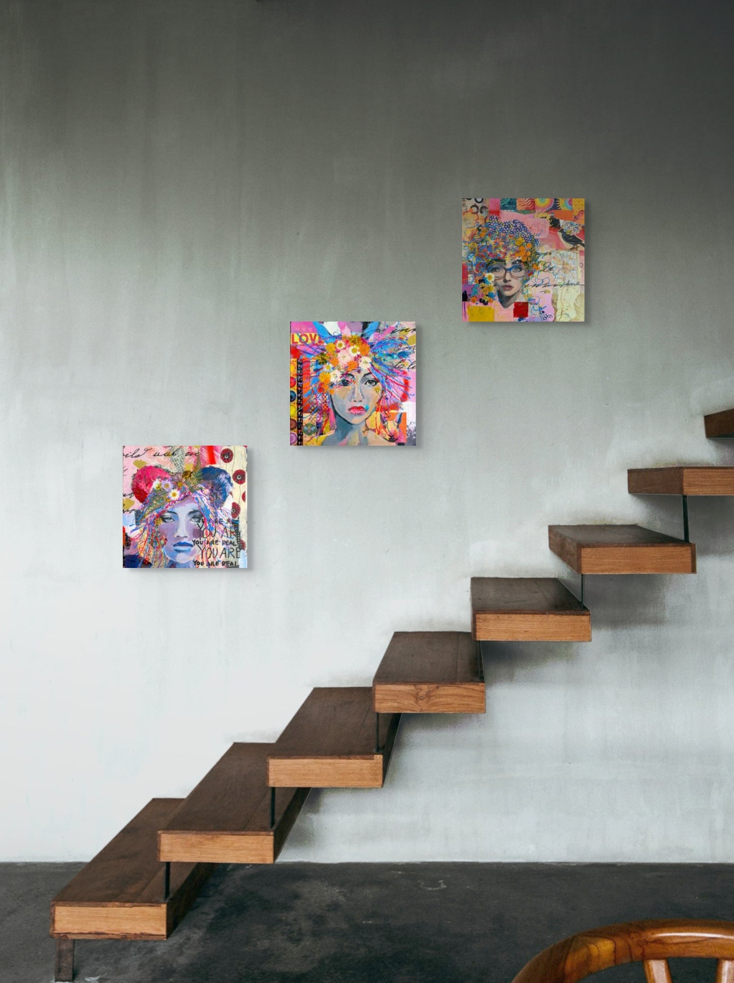 Gina Barnes' three mixed media paintings on a wall above wooden stairs