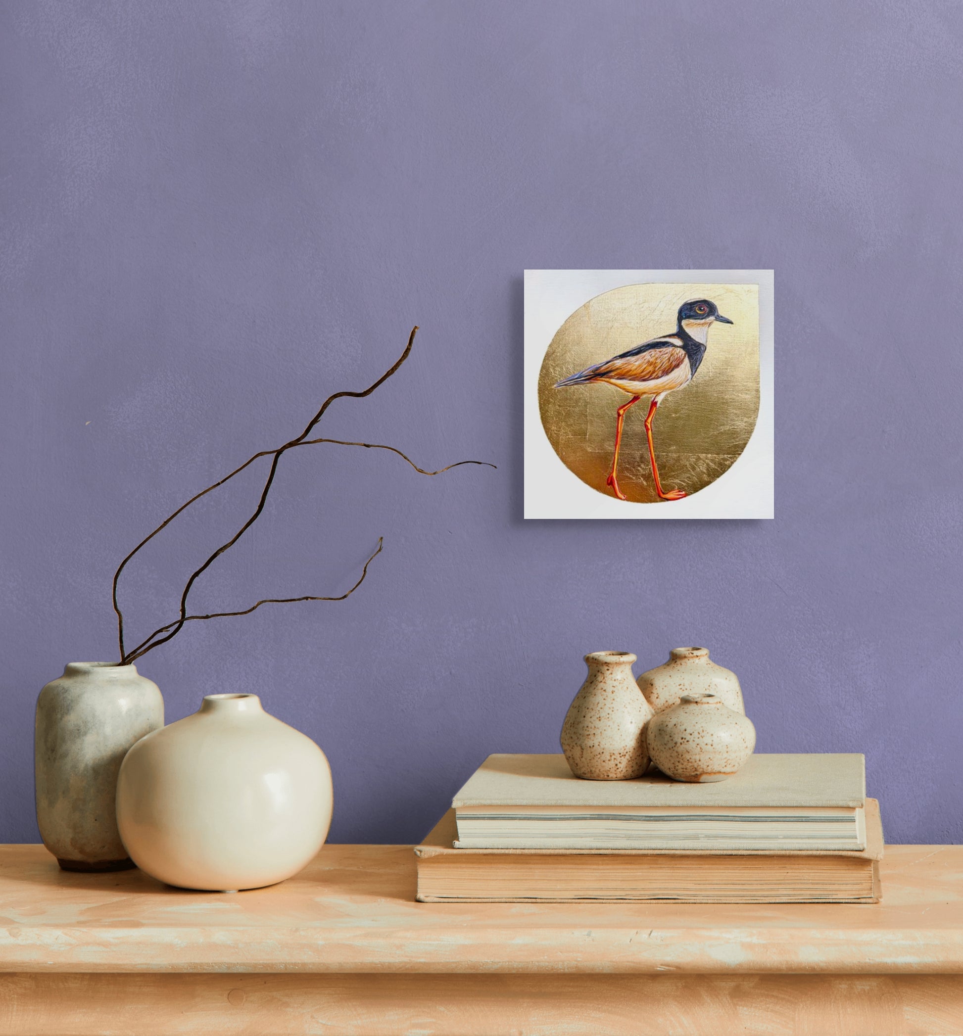 A Pied Lapwing Plover is poised against a background of gold leaf. There are fine details in the featuring in hues of brown, black and cream. Long legs show the delicacy of this water fowl; shown in situ; 8"x8"; shown in situ