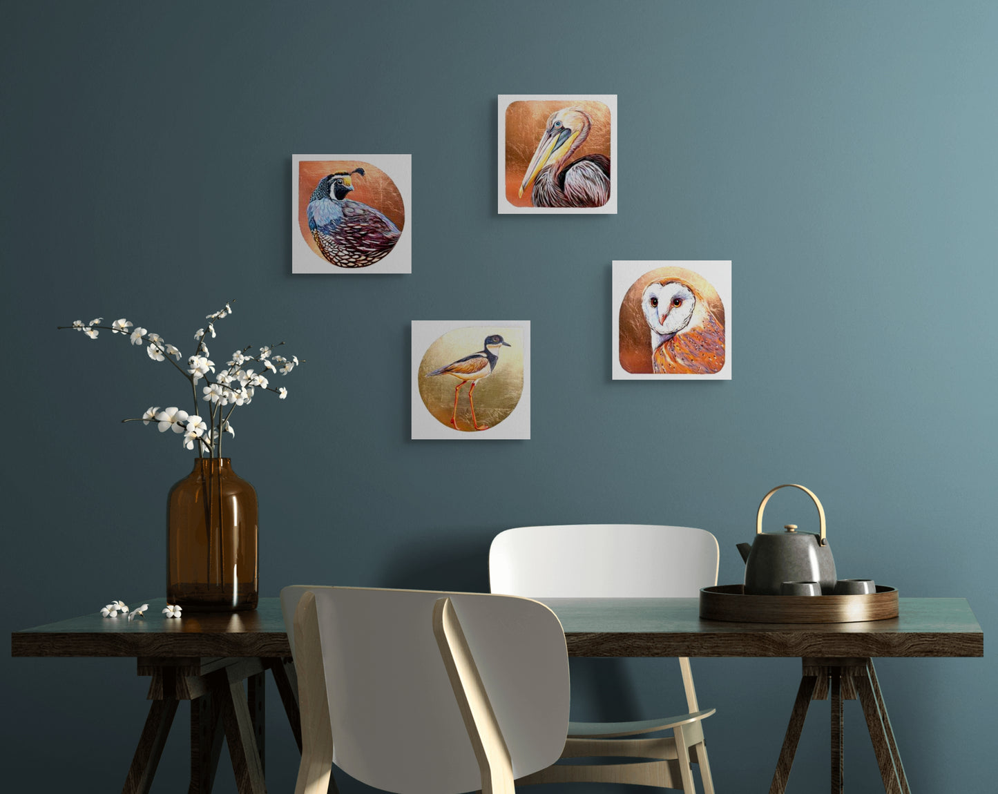 An in situ image of four of Marie Lavallee's 8"x8" mixed media painted bird images on wall; Barn Owl, Pied Lapwing Plover, Pelican, California Quail; all have gold or copper leaf backgrounds