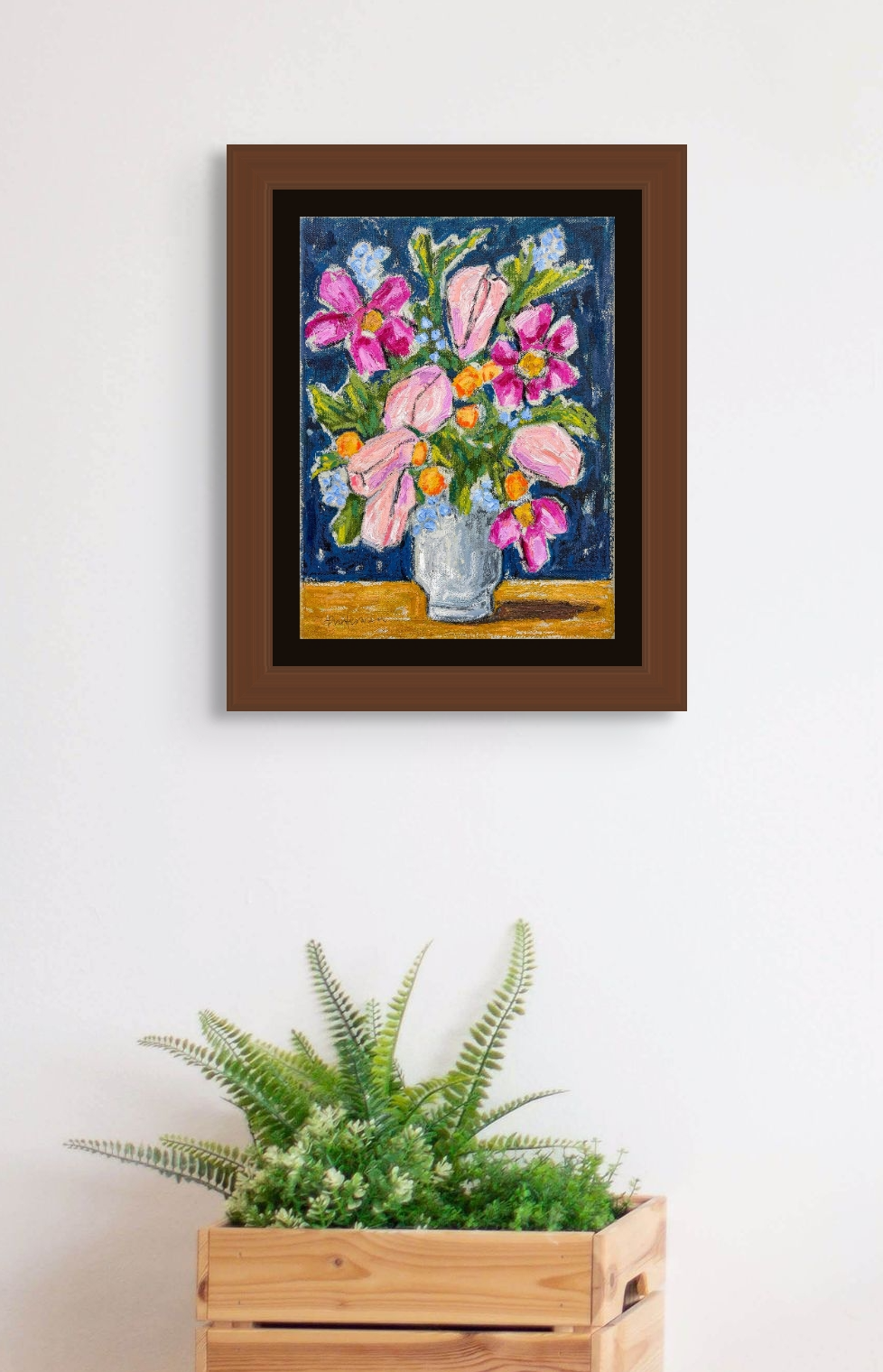 This in situ image shows The Mix Up in a wooden frame hanging over a plant in a wooden crate. The wall is white.