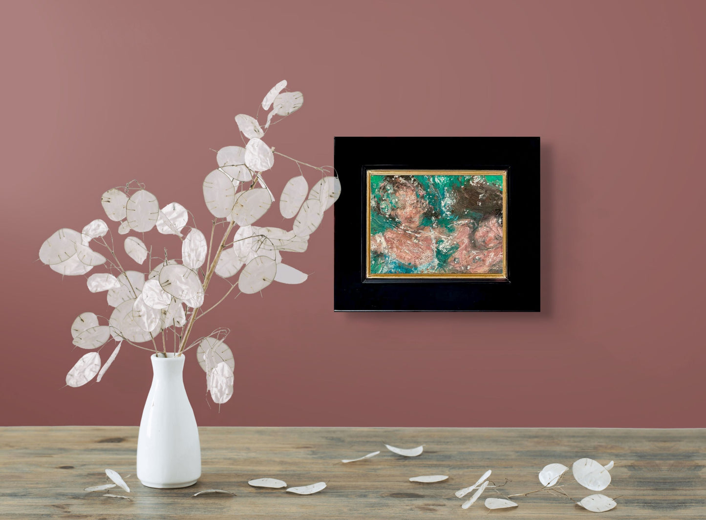 A painting of two faces appearing submerged in water. which swirls across the canvas. Using warmer tones for the skin, set against the cooler hues of green and touches of blue; shown with 2" black wood frame and in situ against rose-colored wall