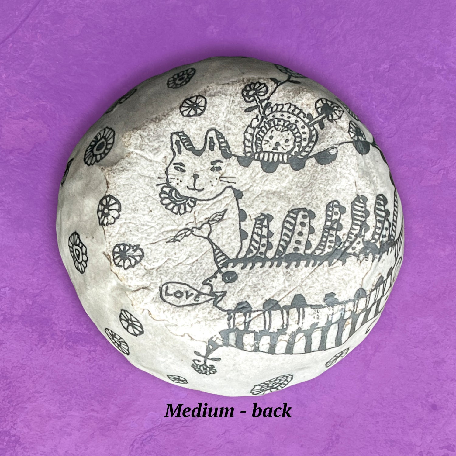 This image shows the backside of the bowl with artistic designs in the shape of a cat and a centipede. The finish is matte, not glossy like the front. 