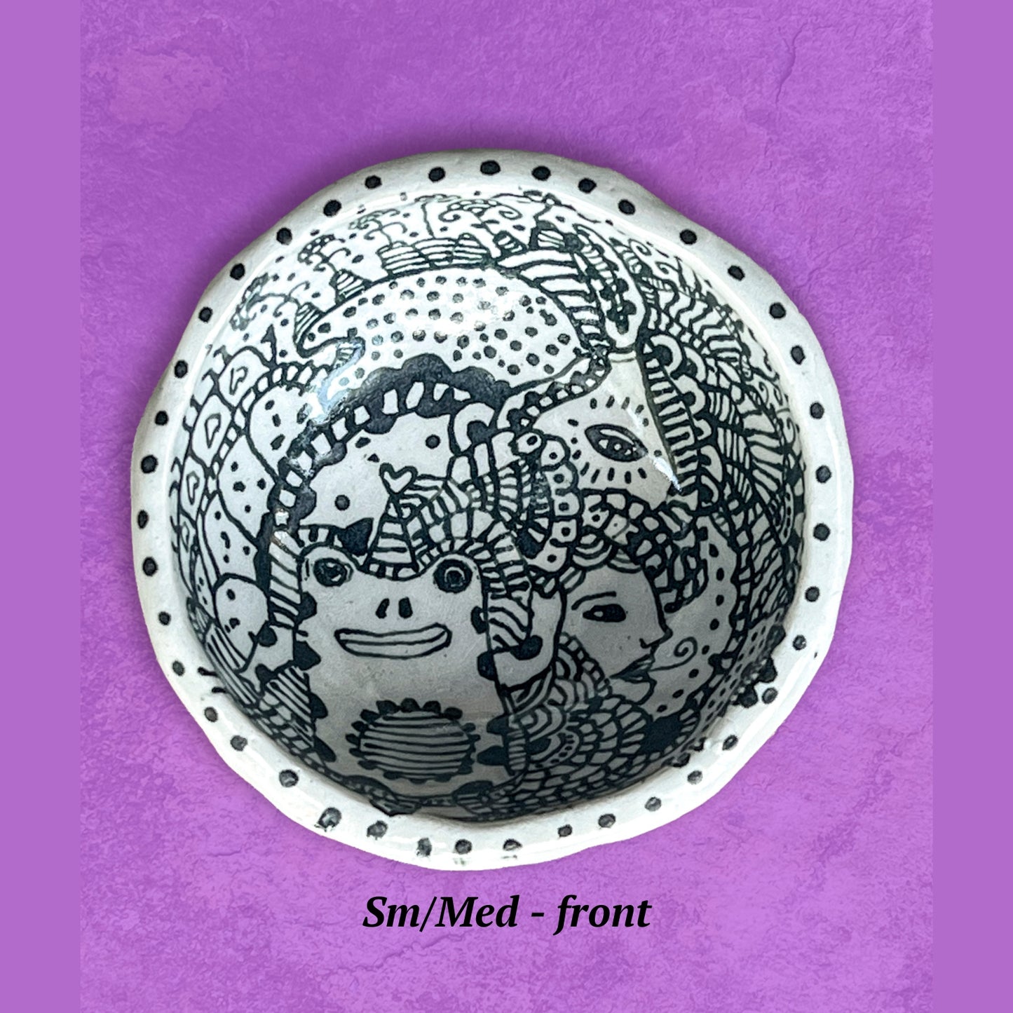 Decorative bowl with a whimsical black and white design. 