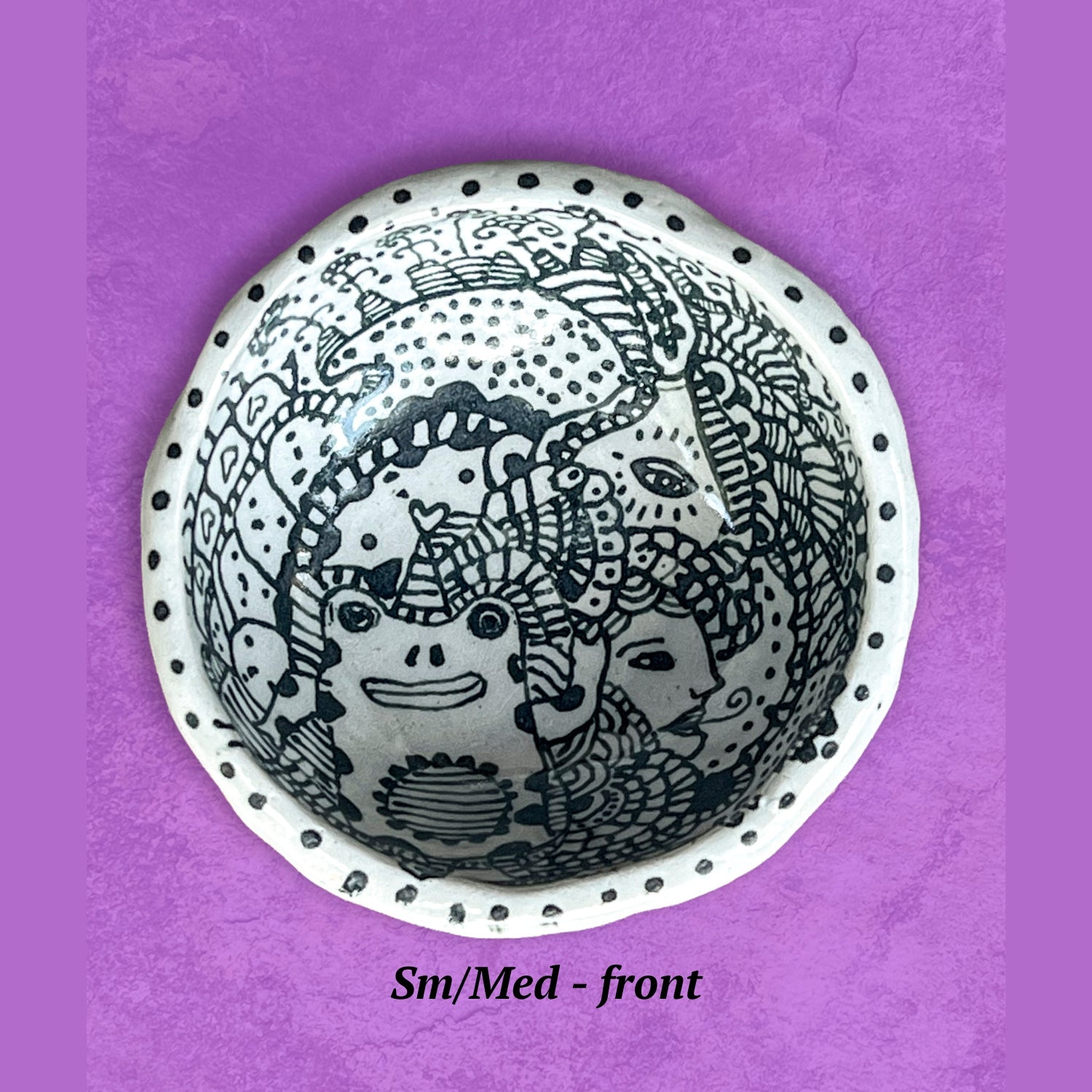 Decorative bowl with a whimsical black and white design. 