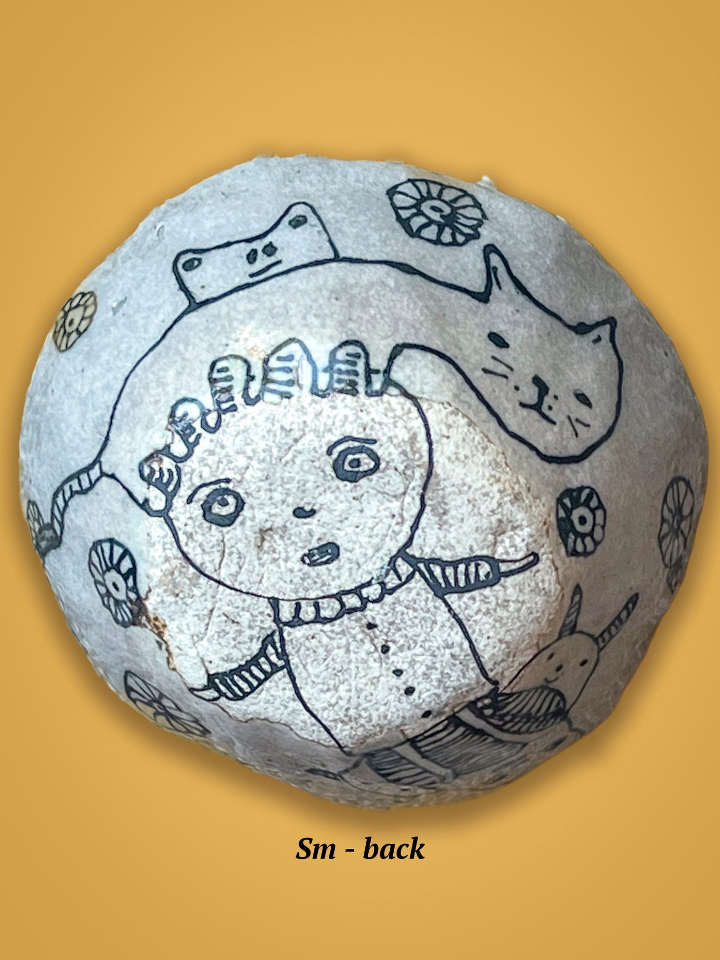 This is the back of the previous bowl with engraved face and cat design in black drawing on a white, un-glossed surface.