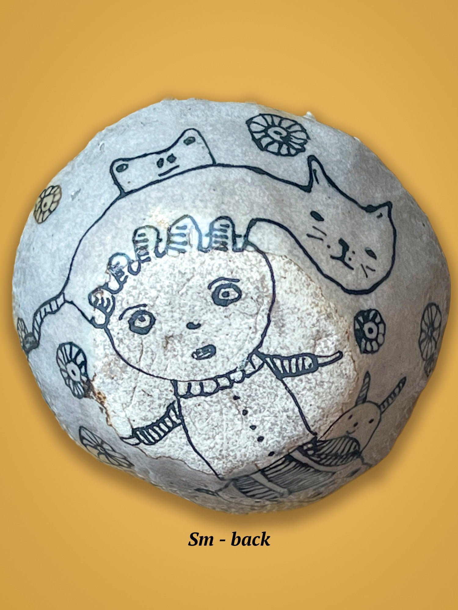 This is the back of the previous bowl with engraved face and cat design in black drawing on a white, un-glossed surface.