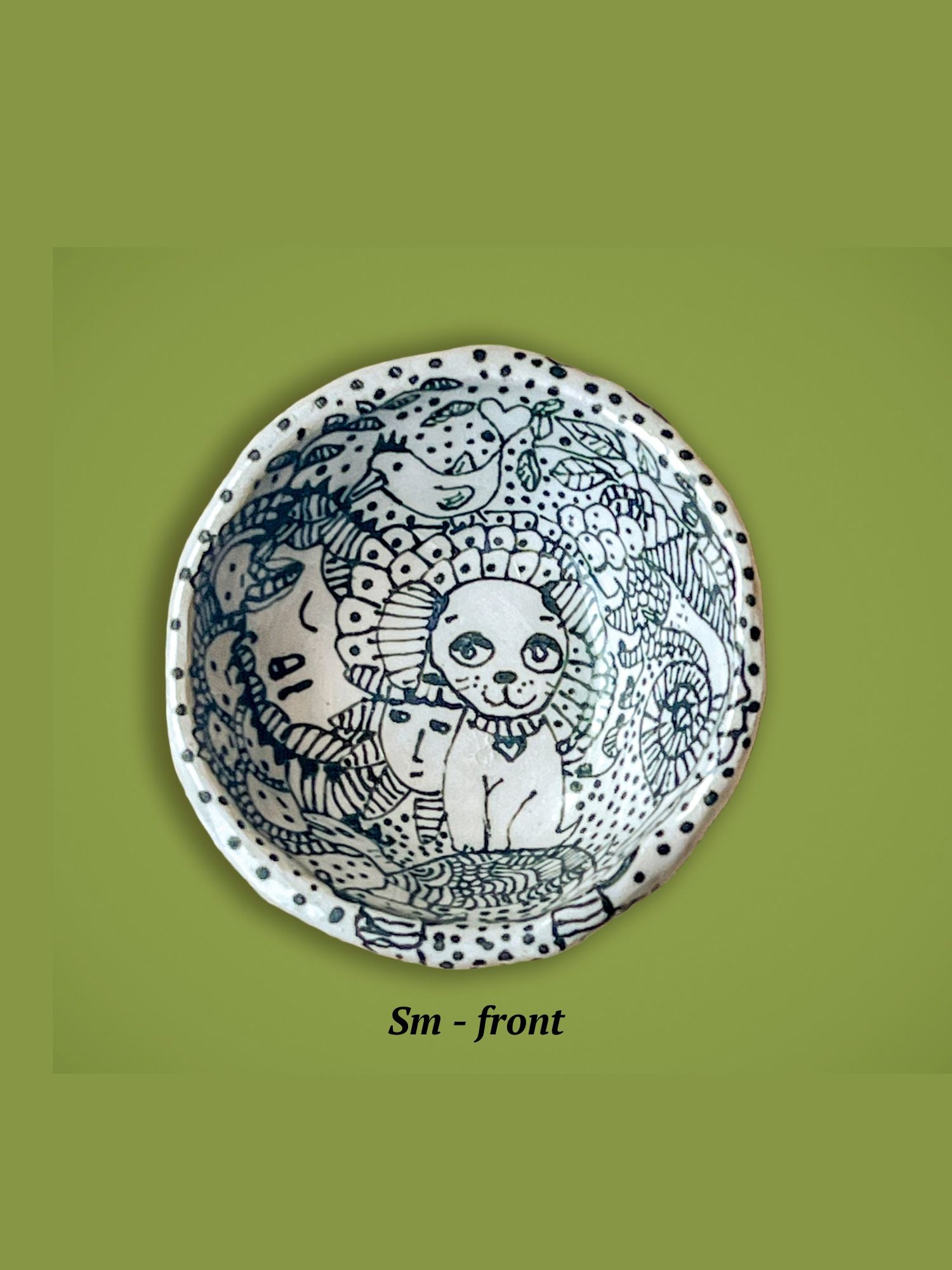 Decorative bowl with black and white designs. The center figure is a dog standing on a turtle.