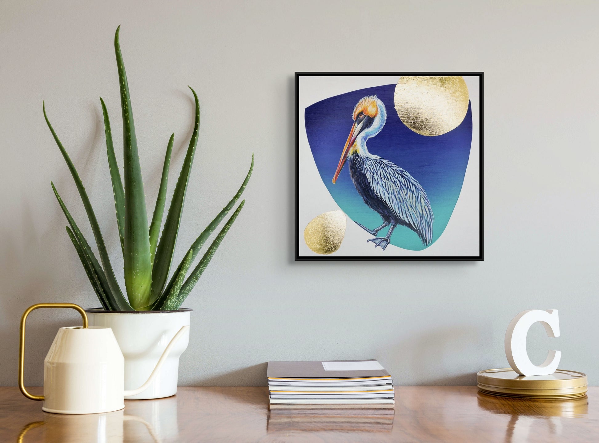 Blue hued pelican on a dark blue background with gold leaf moon and additional accents in situ; artist Marie Lavallee; 10"x10"