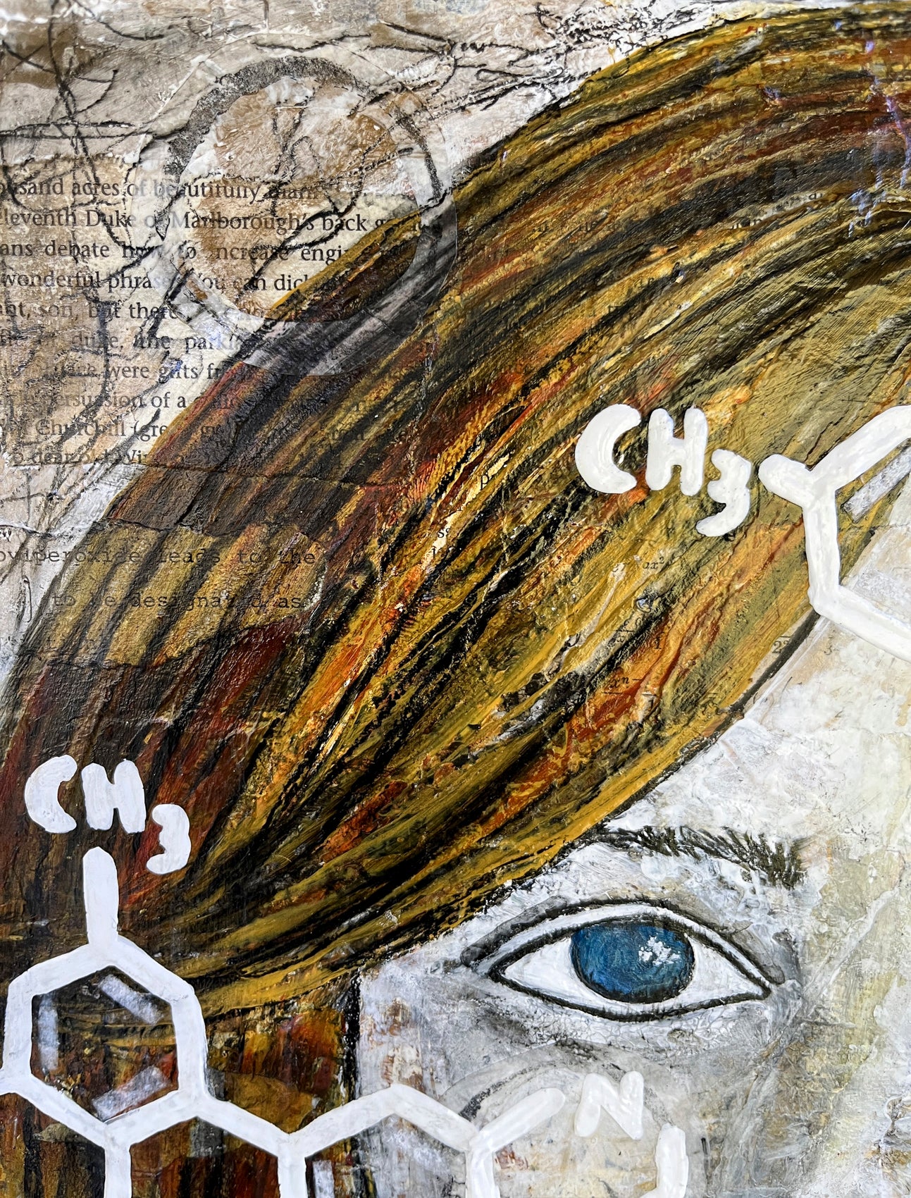 Close up view of the top of the woman's face showing her green blue eye, hair and the mixed media paper collage in the background.