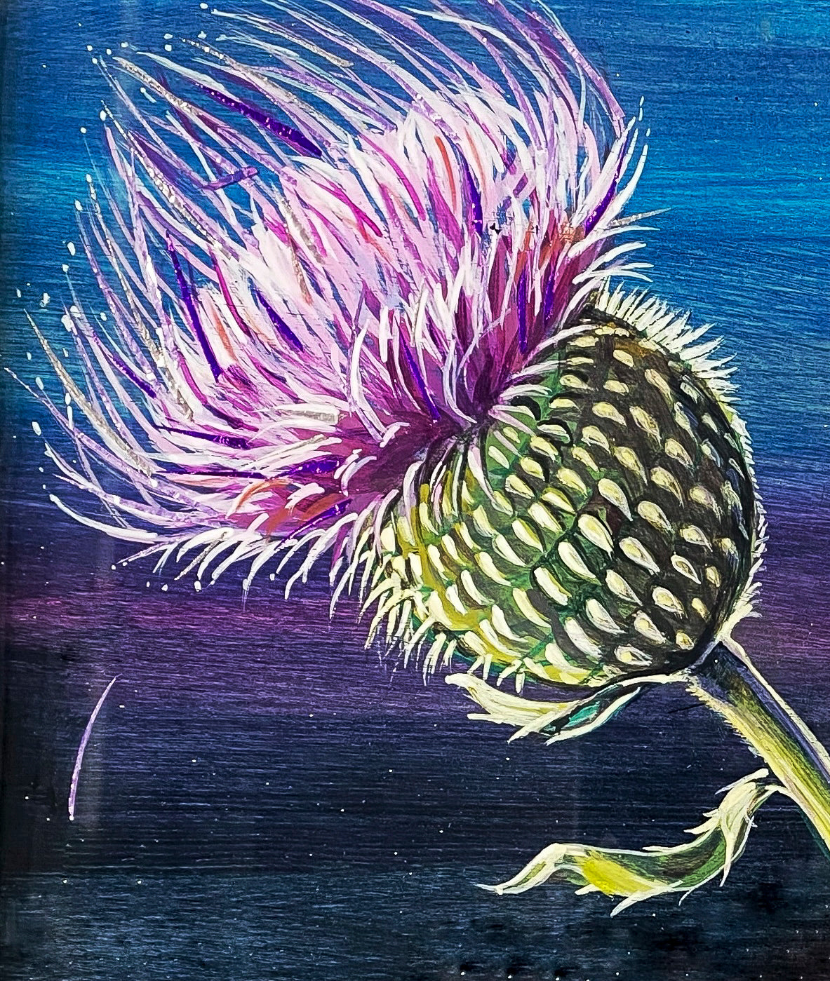 Closeup of painted thistle on larger painting of colorful yellow and black Goldfinch perched on the stem of a thistle shaking its pollen against a lilac and navy metallic background; artist Marie Lavallee