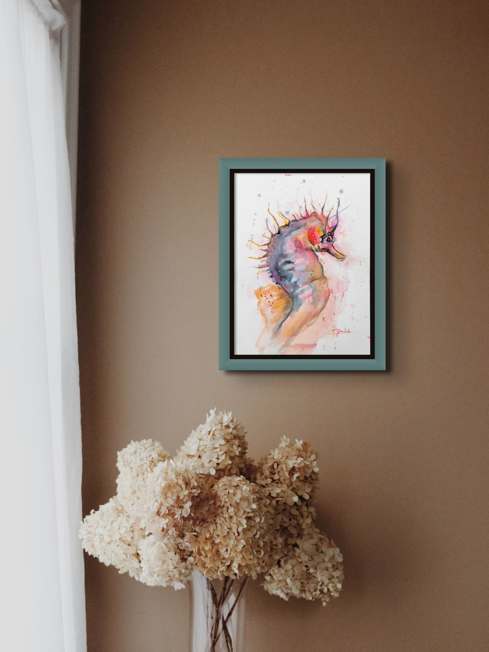 Watercolor painting of sea horse titled 'Horsing Around' by artist Teri Gammalo, floated against black background  with blue painted wood frame.