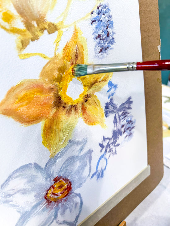 Painting of yellow and blue flowers with artist's brush