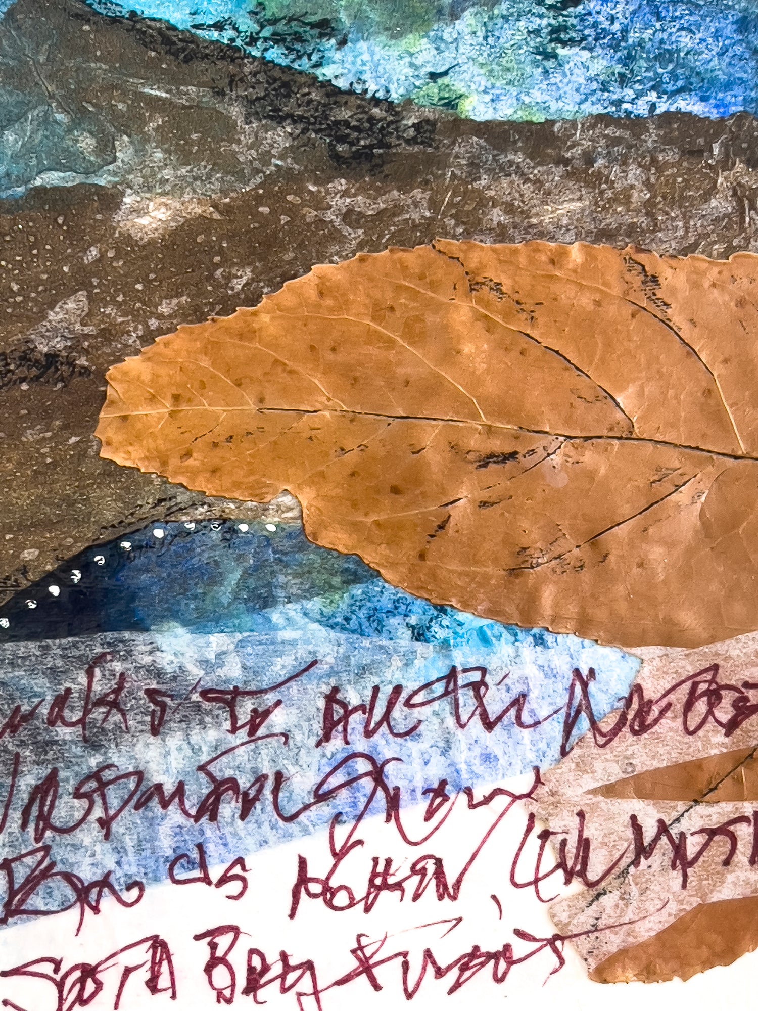 Close up image of the dried leaf which is the central focus of the collage, as well as a few lines of unreadable writing.