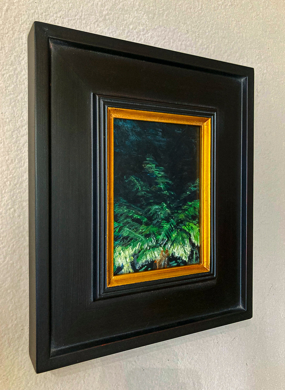Oil painting of top of palm tree using shades of green titled 'In the Dark' by E. E. Jacks with dark wood frame and inner gold gild