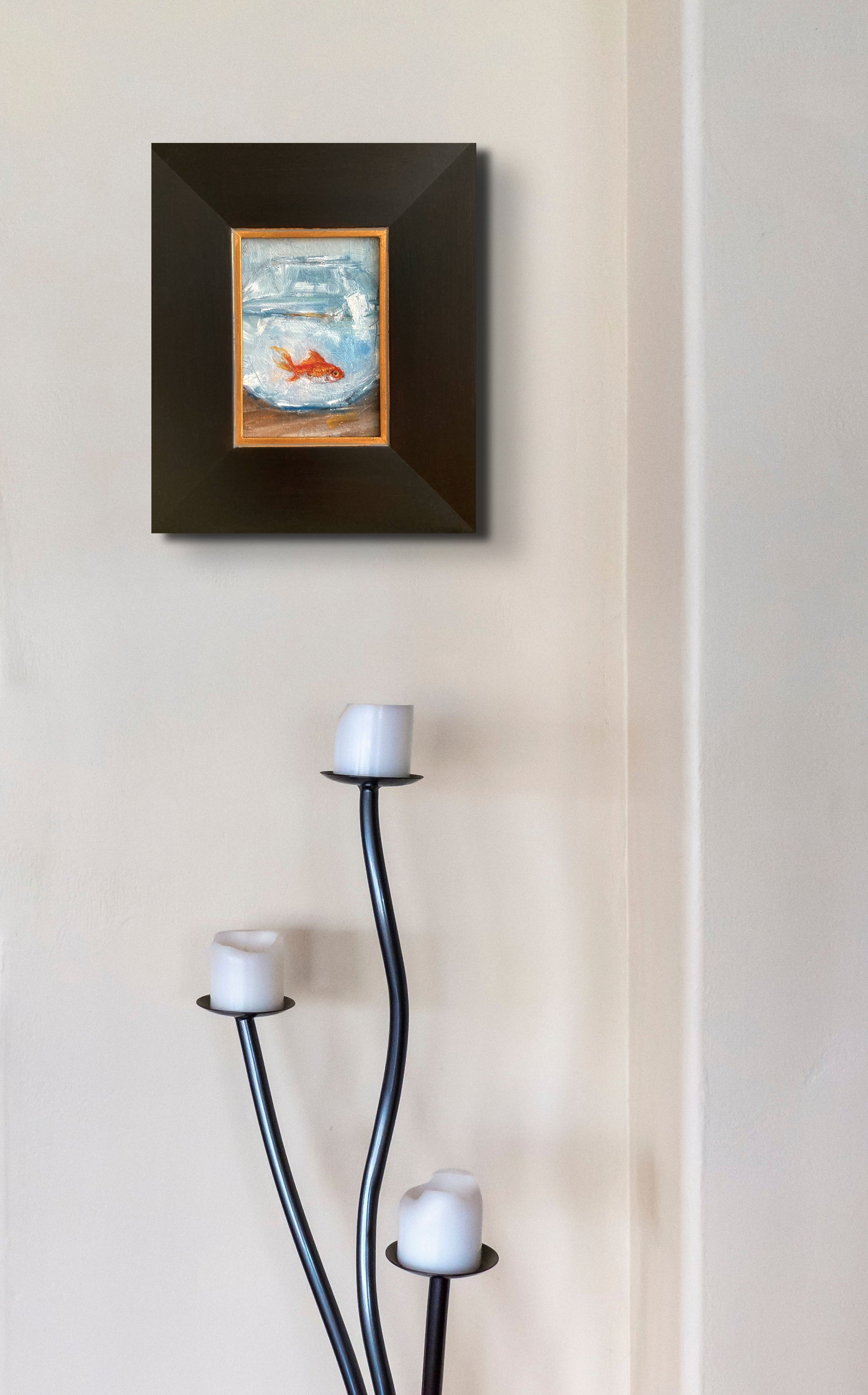 In situ photo of framed goldfish painting on wall with candlestick