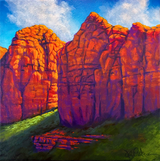 Shadowing is one of Joe A. Oakes signatures and this piece highlights the shadows of two rock formations in the southwestern landscape. The rocks are brilliant orange with purple shadows. The sky blue with hints of white clouds. Green terrain serves as the bottom of the painting. 