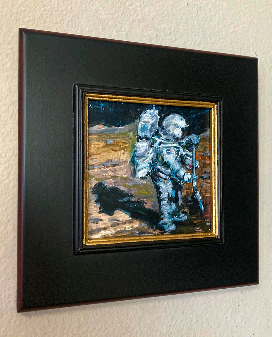 Oil painting of astronaut walking on lunar landscape titled 'Moon Walk' by E. E. Jacks with dark wood frame and inner gold gild edge.
