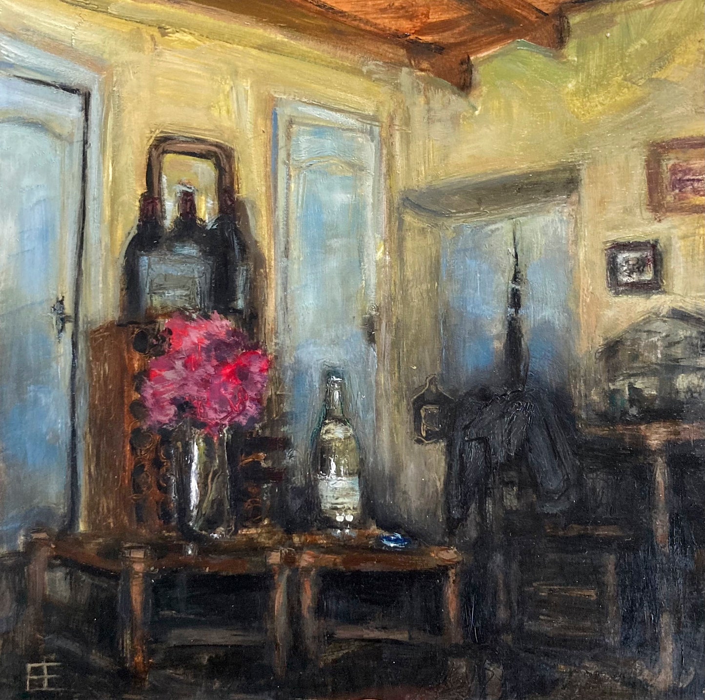 Image is of a small room with yellow walls. Windows are to each side of a bookshelf and table with a bottle of wine and vase of flowers. A corner shows the beamed wooden celing.