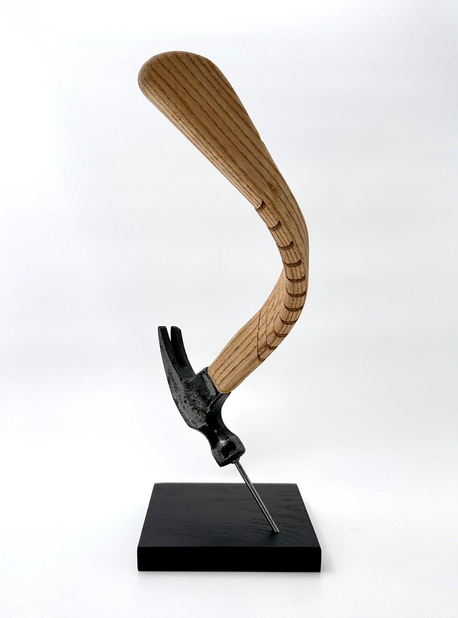 This is another angle, from the side of the sculpture demonstrating the curve of the handle and the balance of the hammer on the nail. 