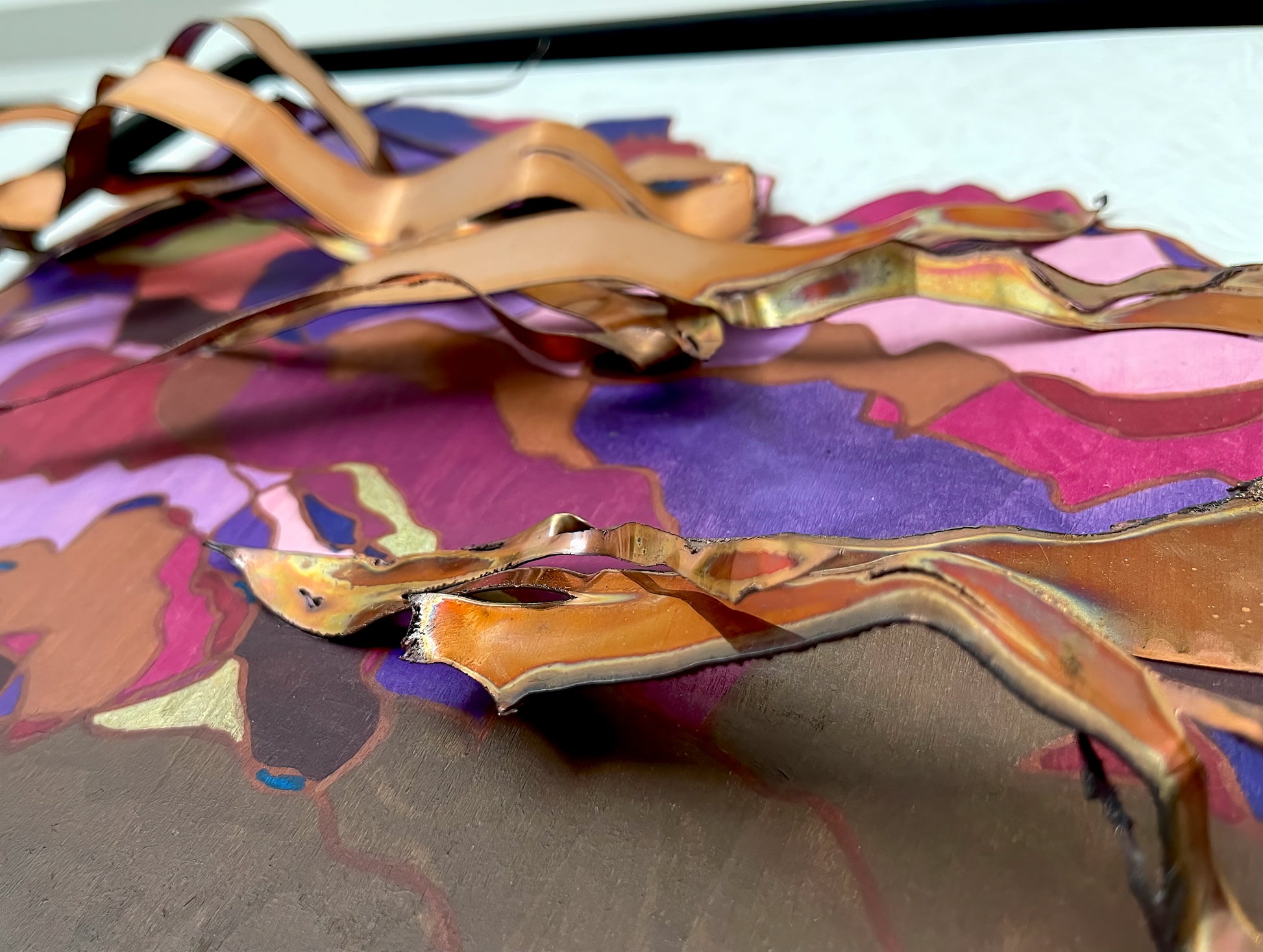 The copper rests above the acrylic on the birchwood panel, creating a three dimensional piece.