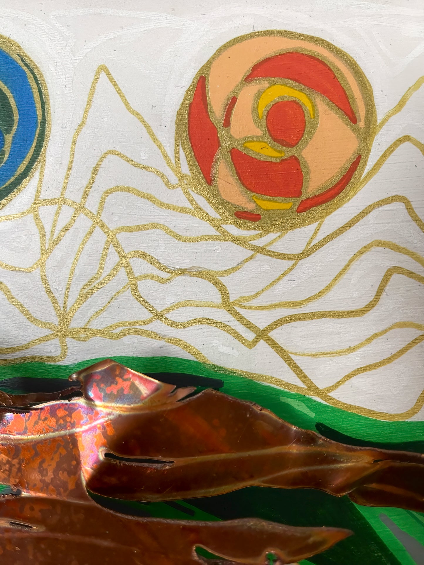 Here is a close up of an orange-tone multicolored orb highlighted with gold lines that continue throughout the white background. Also shown is a piece of the copper. 