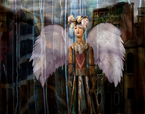 A digital composite image using fragments of photographs to form a wooden angel with pink wings; 10