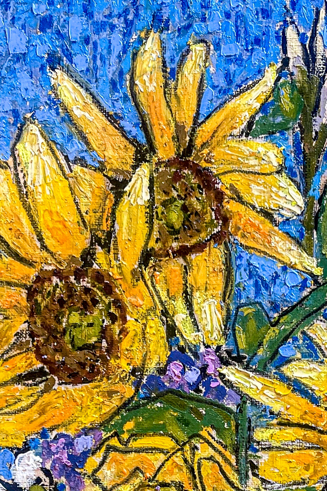 Image shows a close up of the yellow sunflowers with brown centers. The textures of the oil pastels  on the royal blue background are emphasized in this image.