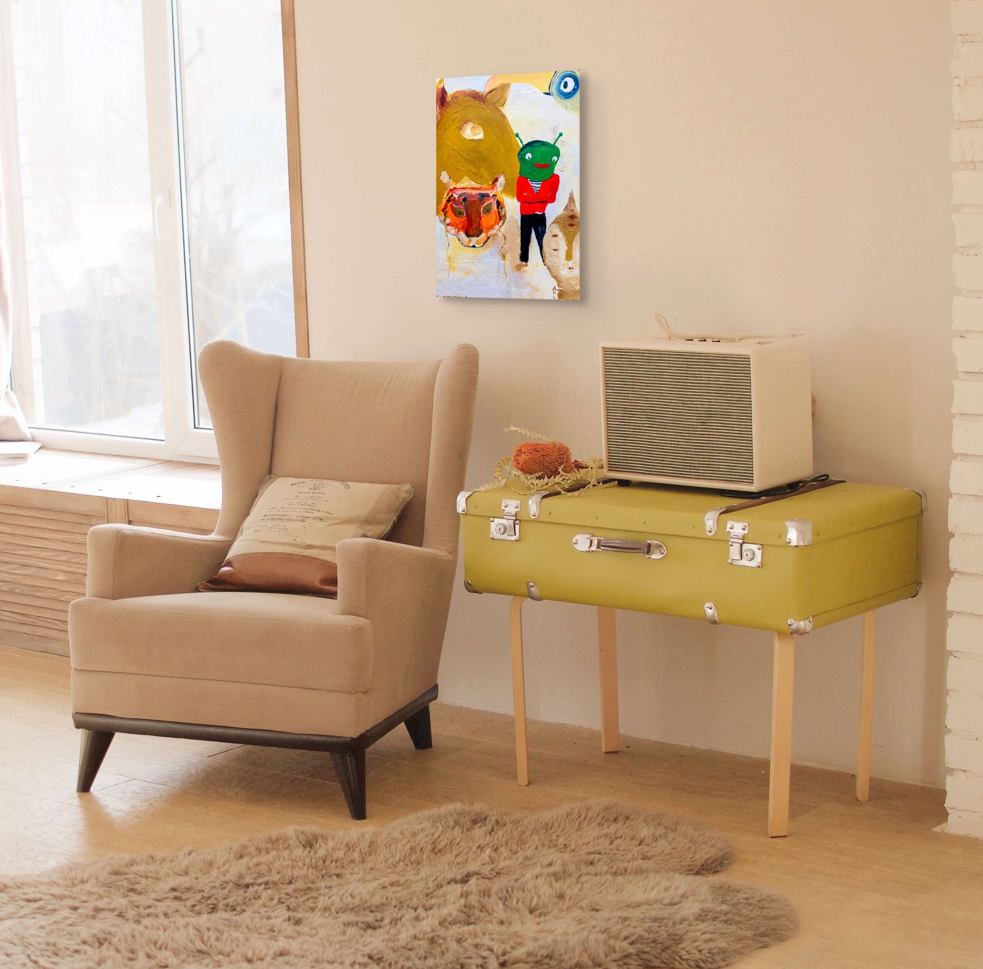 This in situ image shows April Bedard's  "Alien" hanging on a light tan wall over a wing backed chair, a side table that resembles a truck and an old radio.