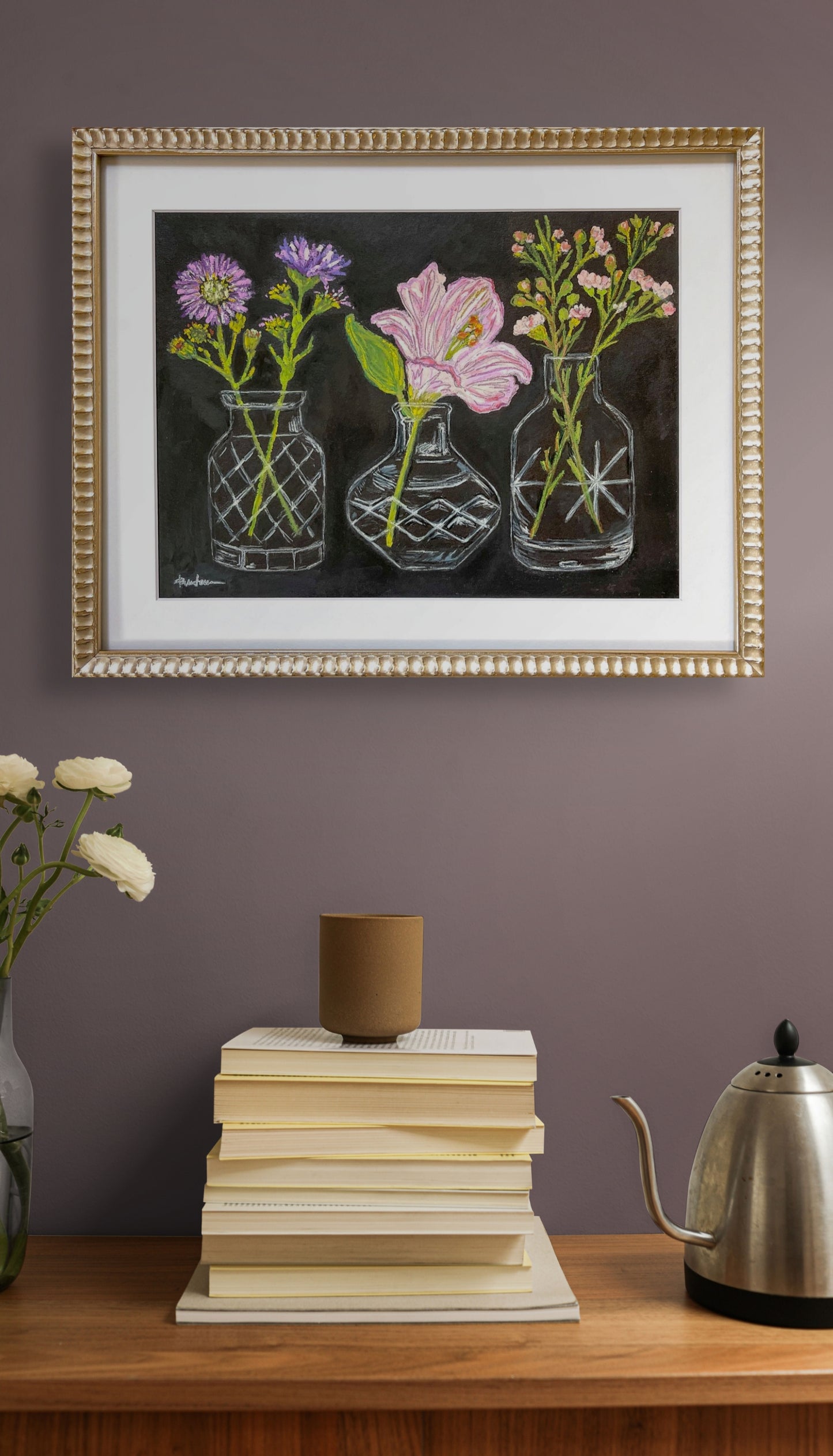 Crystal Clear is shown here in its gold metal frame hanging on a taupe wall over a counter with books and a teapot
