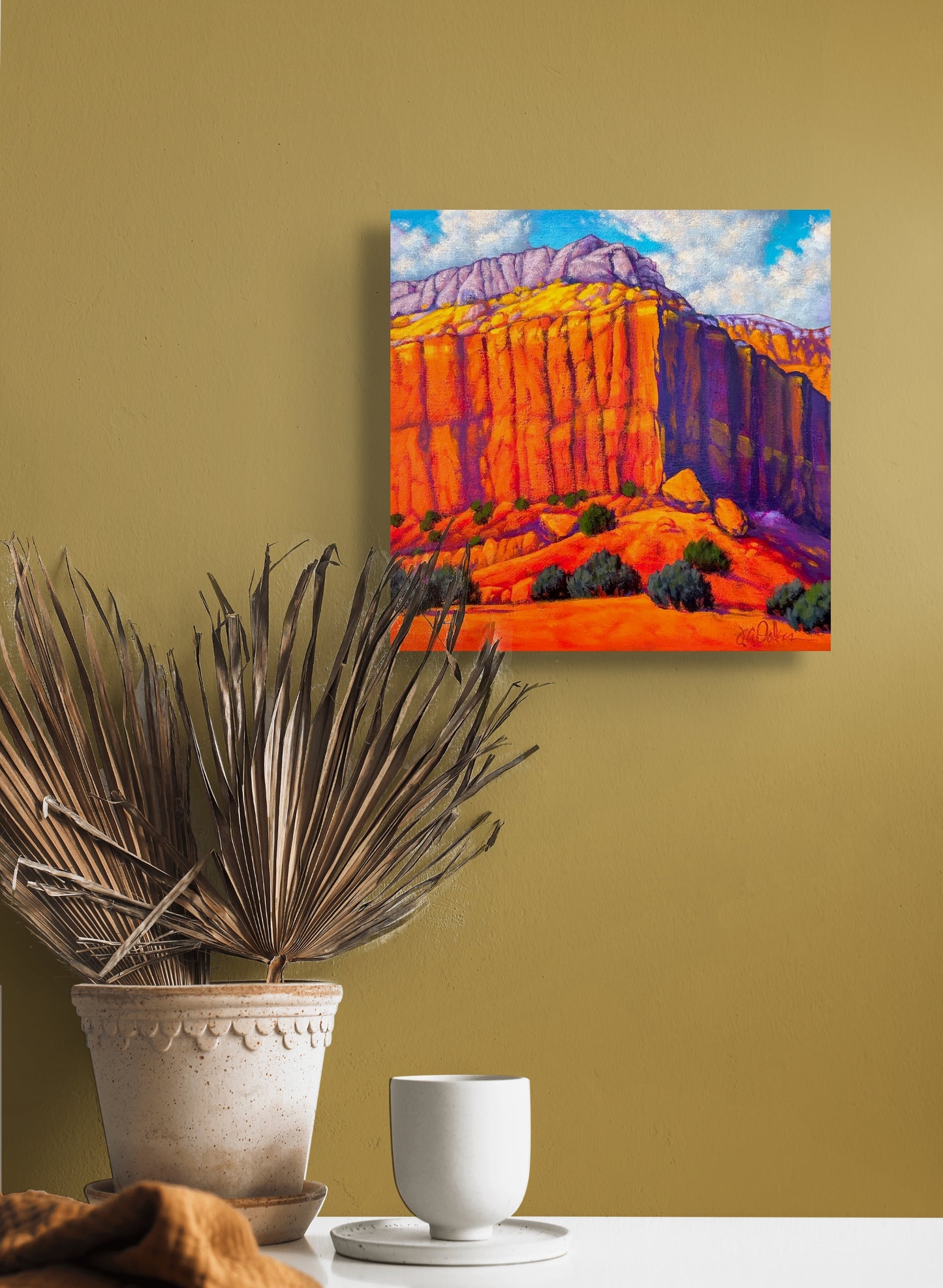 The in situ image shows Desert Strata hanging on a light brown wall over a table adorned with a vase.