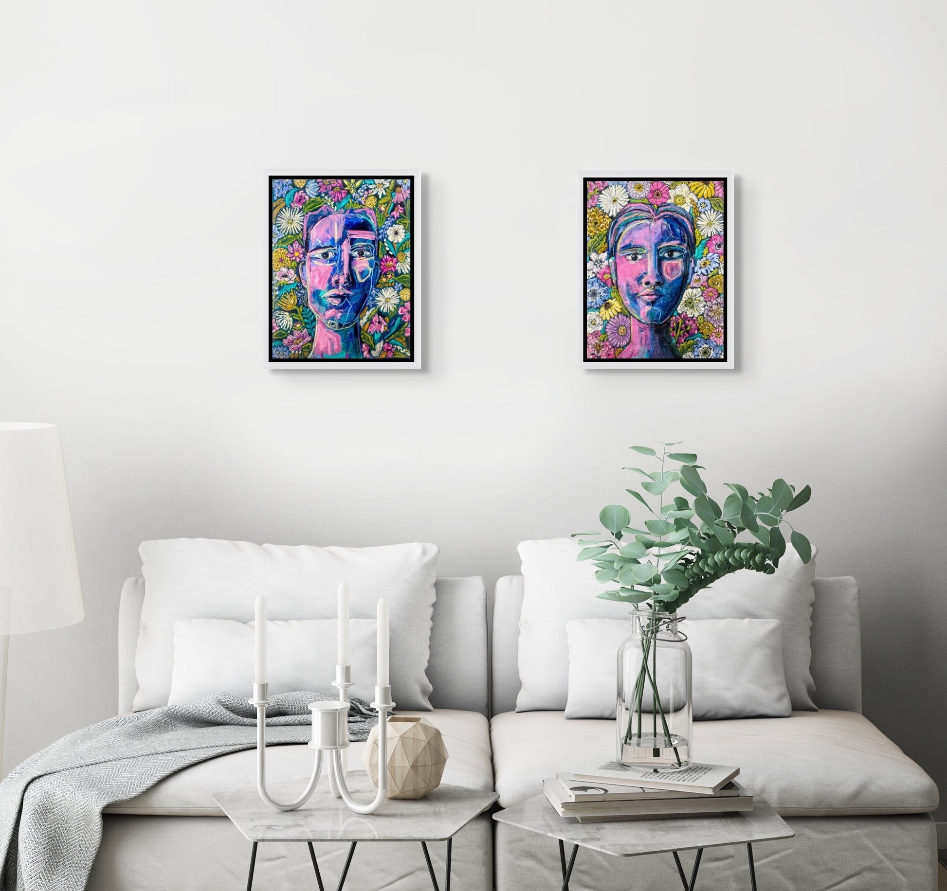 In situ image shows the pair of Rachel Bunteman's abstract portraits - Garden Repose and Finding Center, hanging over a white couch with two decorated tables. 