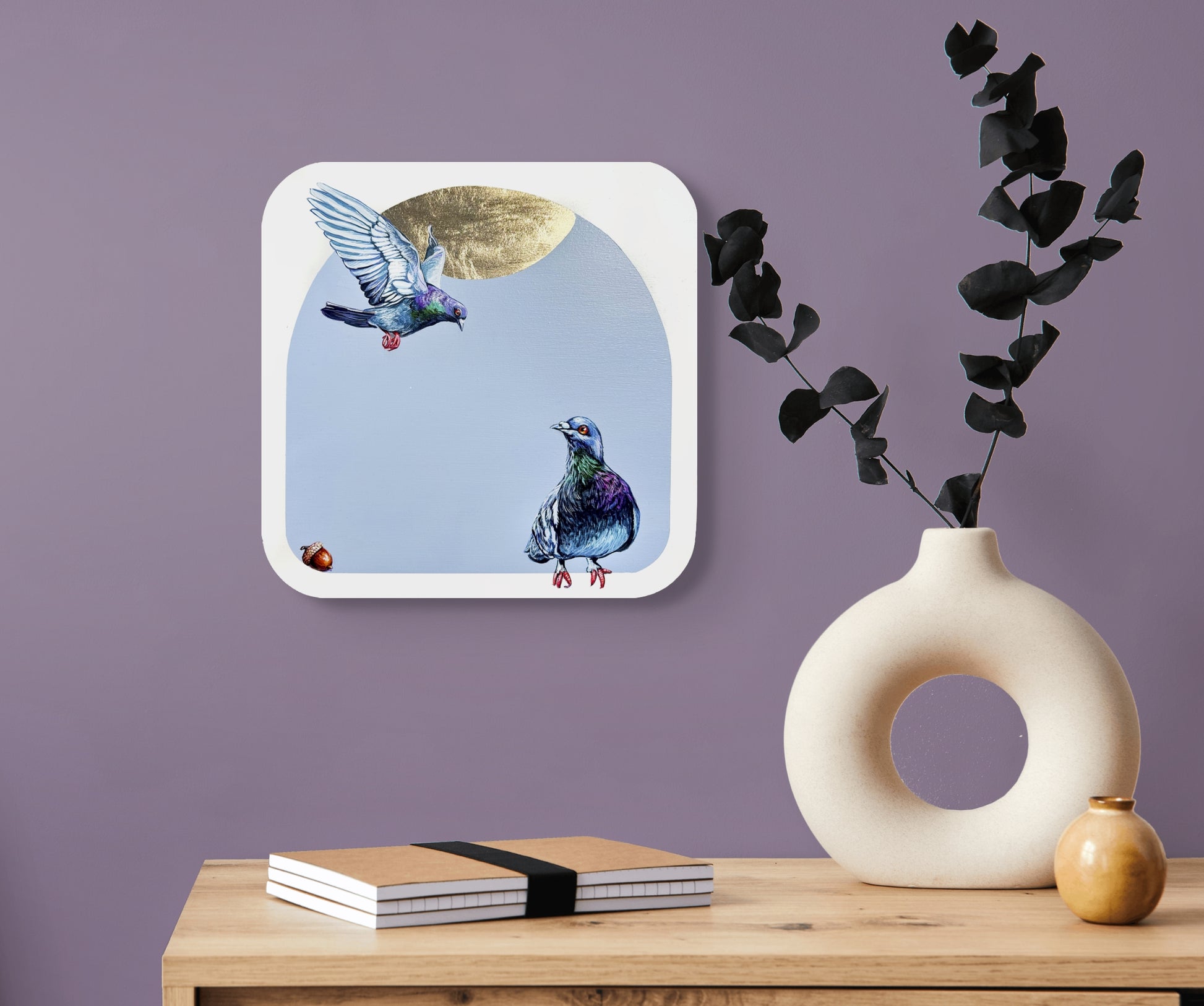 Closeup of flying pigeon and another roosting pigeon; on lavender background w/gold leaf enhancement; 13"x13" artist Marie Lavallee; shown in situ